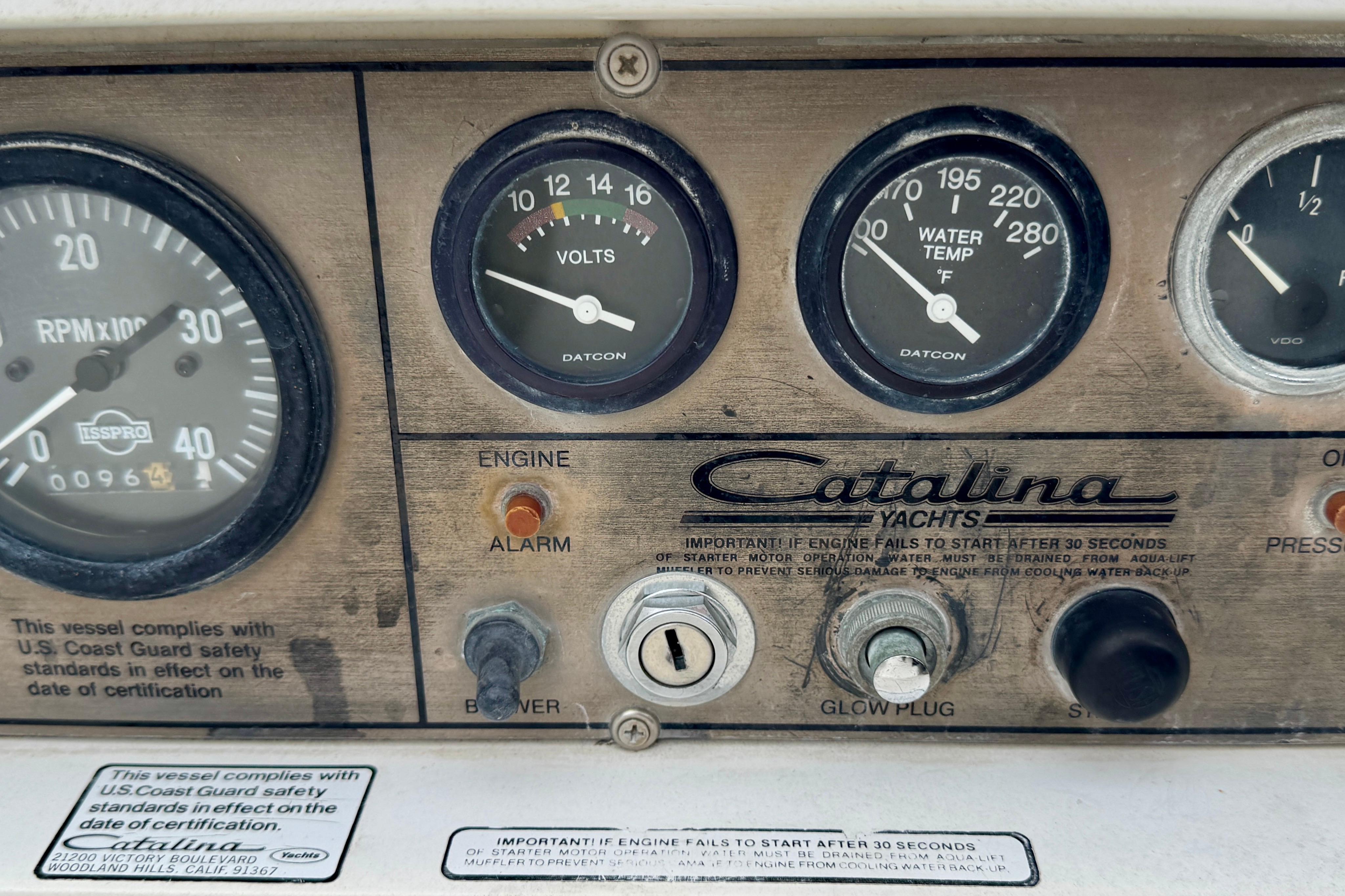 Control panel of a 1986 Catalina 36 yacht with gauges and switches.