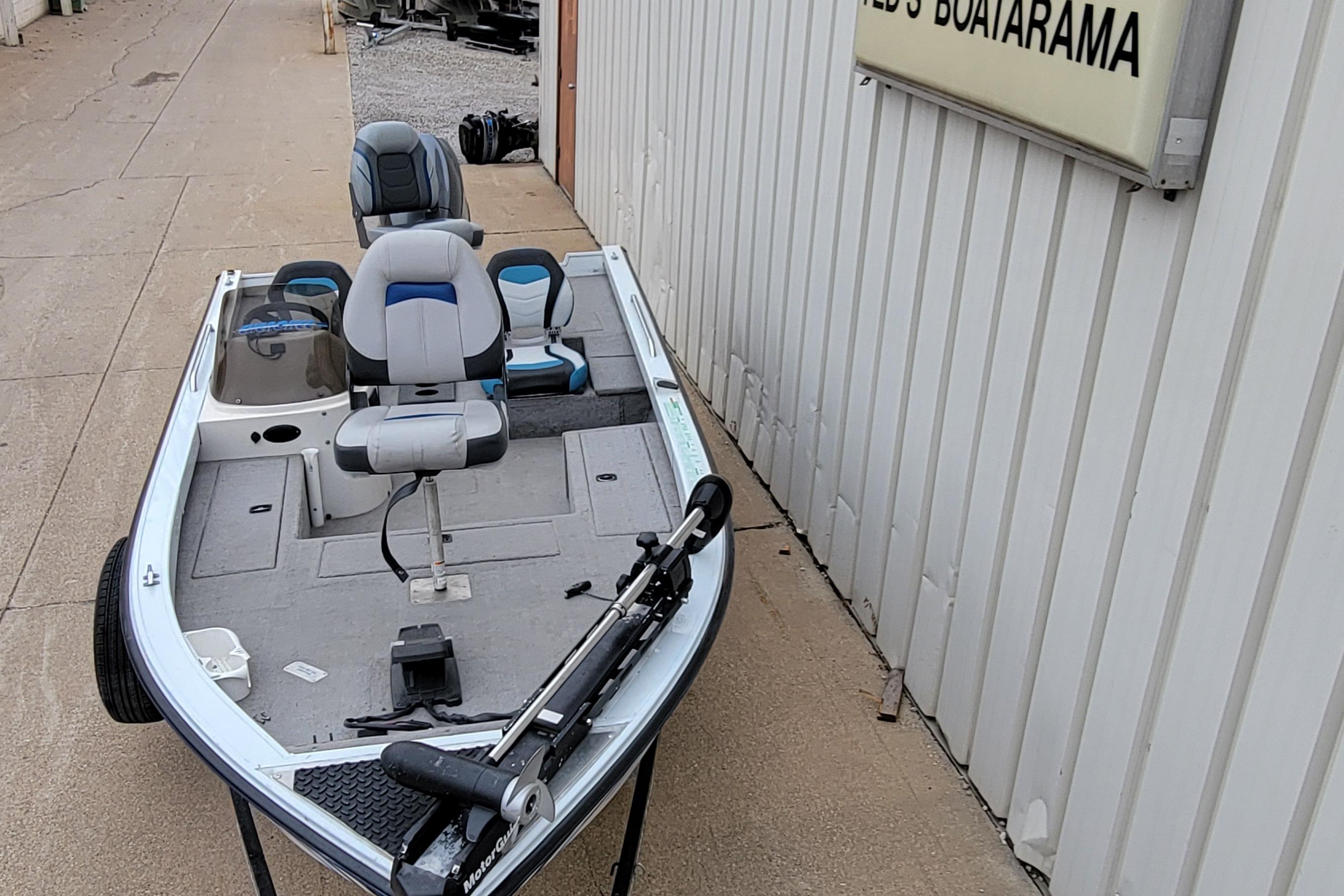 1999 Ranger 107 Cherokee fishing boat with seating and trolling motor, parked outside.