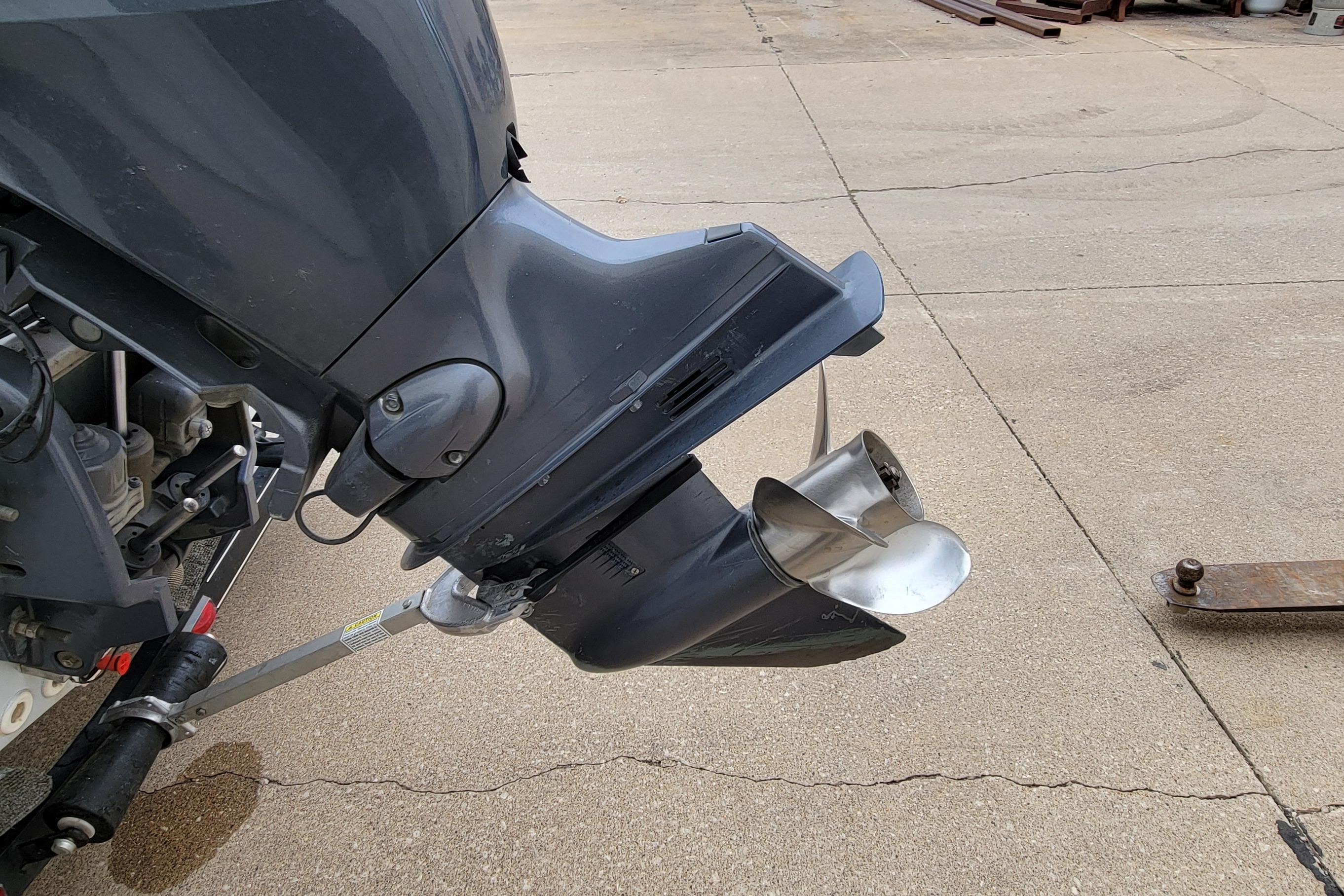 Outboard motor of a 1999 Ranger 107 Cherokee boat on concrete surface.