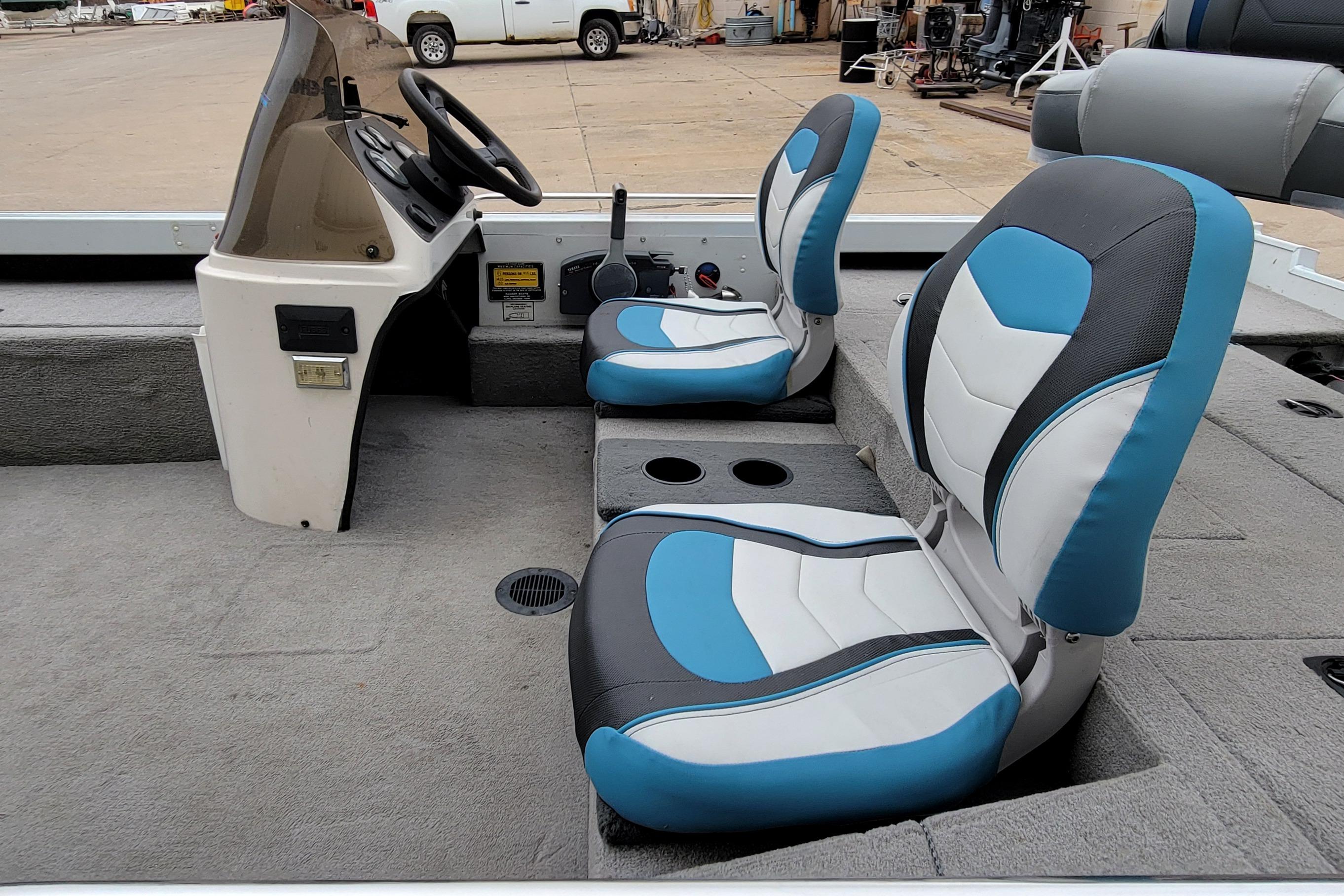 1999 Ranger 107 Cherokee boat interior with blue and white seats, steering console visible.