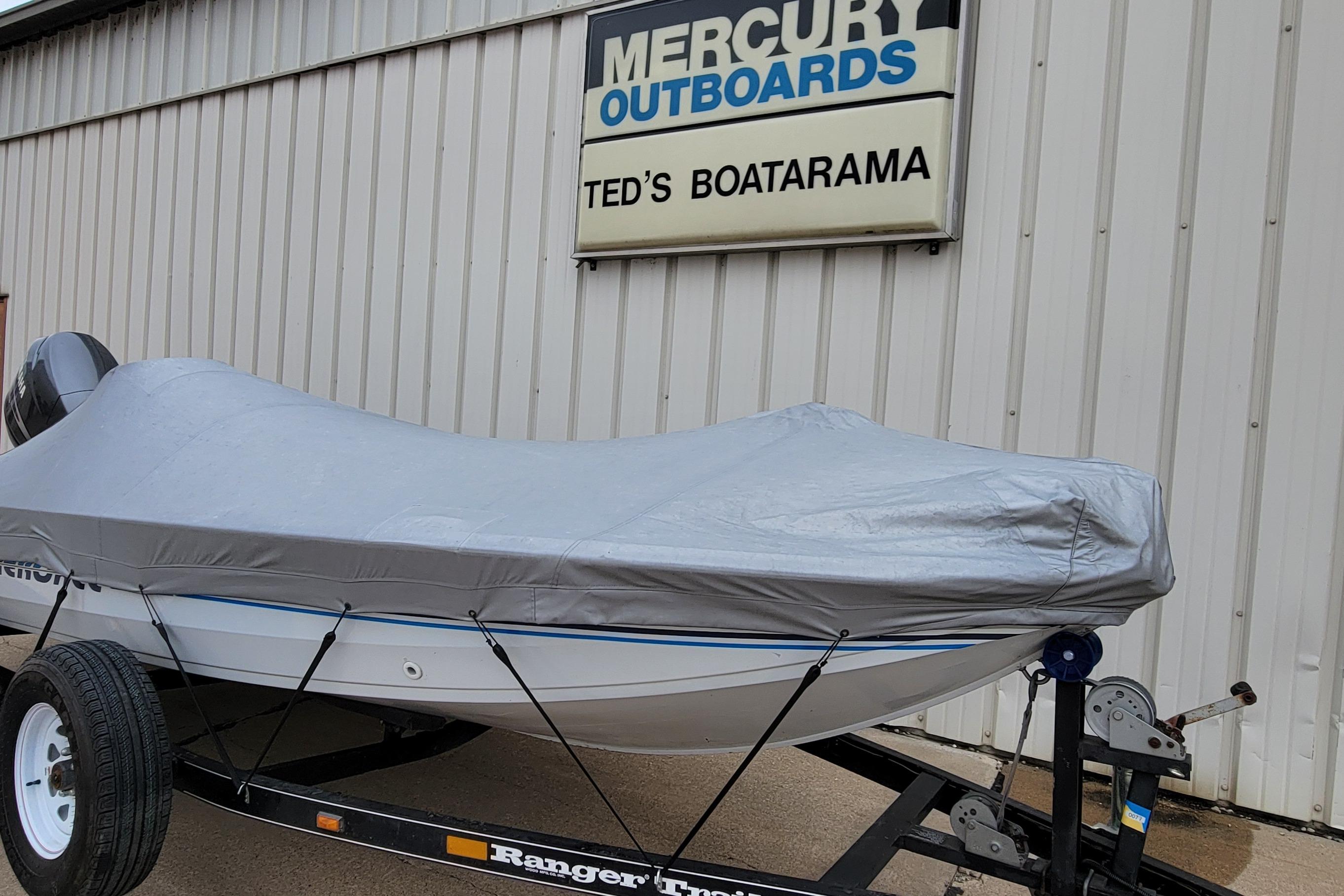 1999 Ranger 107 Cherokee boat covered, parked at Ted's Boatarama, Mercury Outboards sign visible.