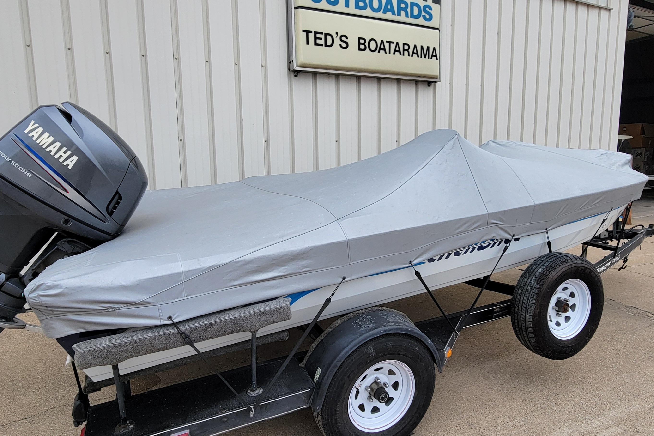 Covered 1999 Ranger 107 Cherokee boat with Yamaha outboard motor on trailer at Ted's Boatarama.