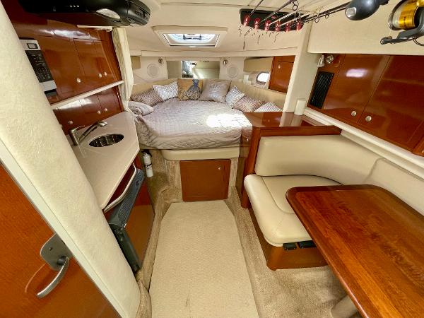 2005 Sea Ray Amberjack 290 cabin interior with bed, kitchenette, and dining area.