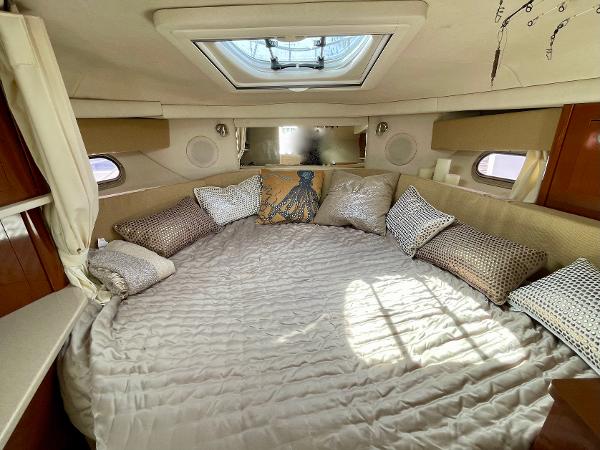 Luxurious cabin interior of 2005 Sea Ray Amberjack 290 with plush bedding and skylight.