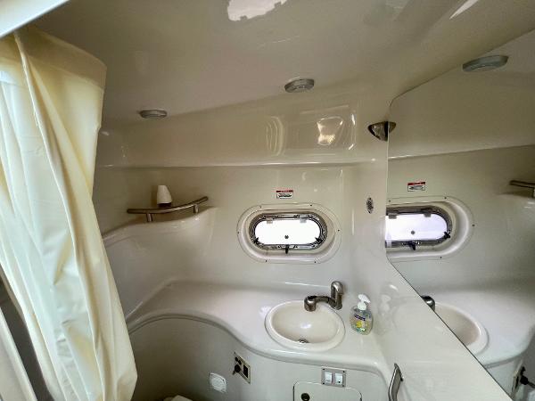 2005 Sea Ray Amberjack 290 bathroom with sink, mirror, and porthole window.