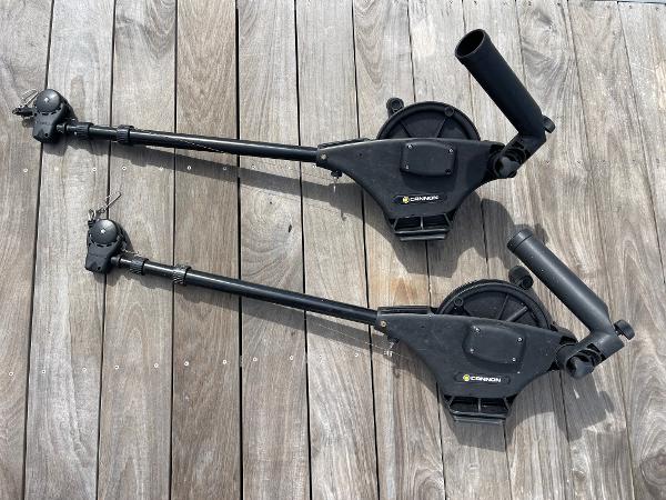 Two black Cannon downriggers on wooden deck, compatible with 2005 Sea Ray Amberjack 290.