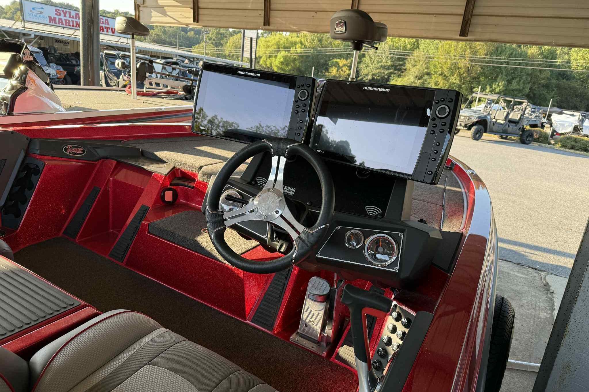 2024 Ranger Z518 boat dashboard with dual monitors and steering wheel in a marina setting.