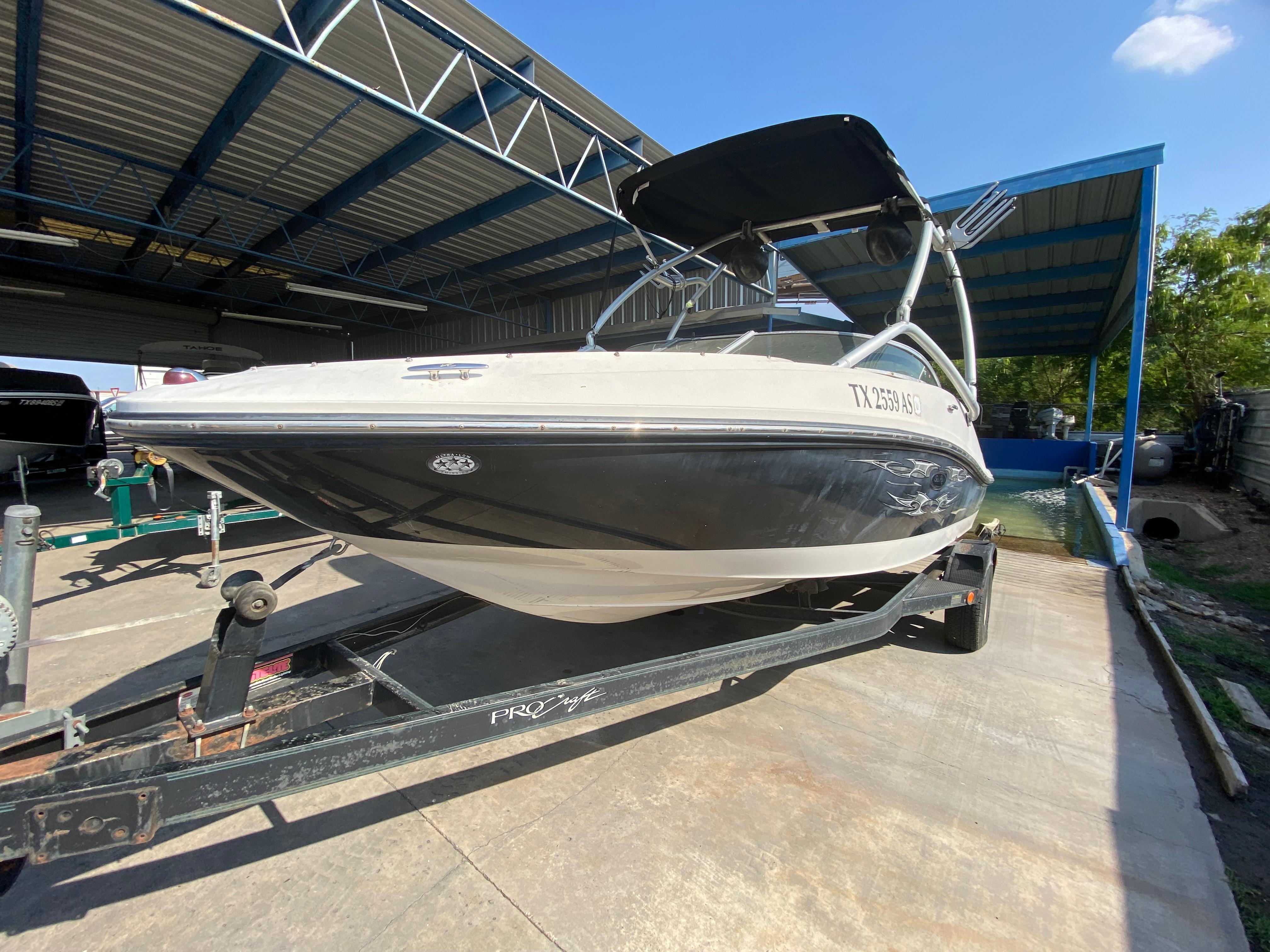 2008 Sea Ray 185 Sport boat on trailer under metal canopy.