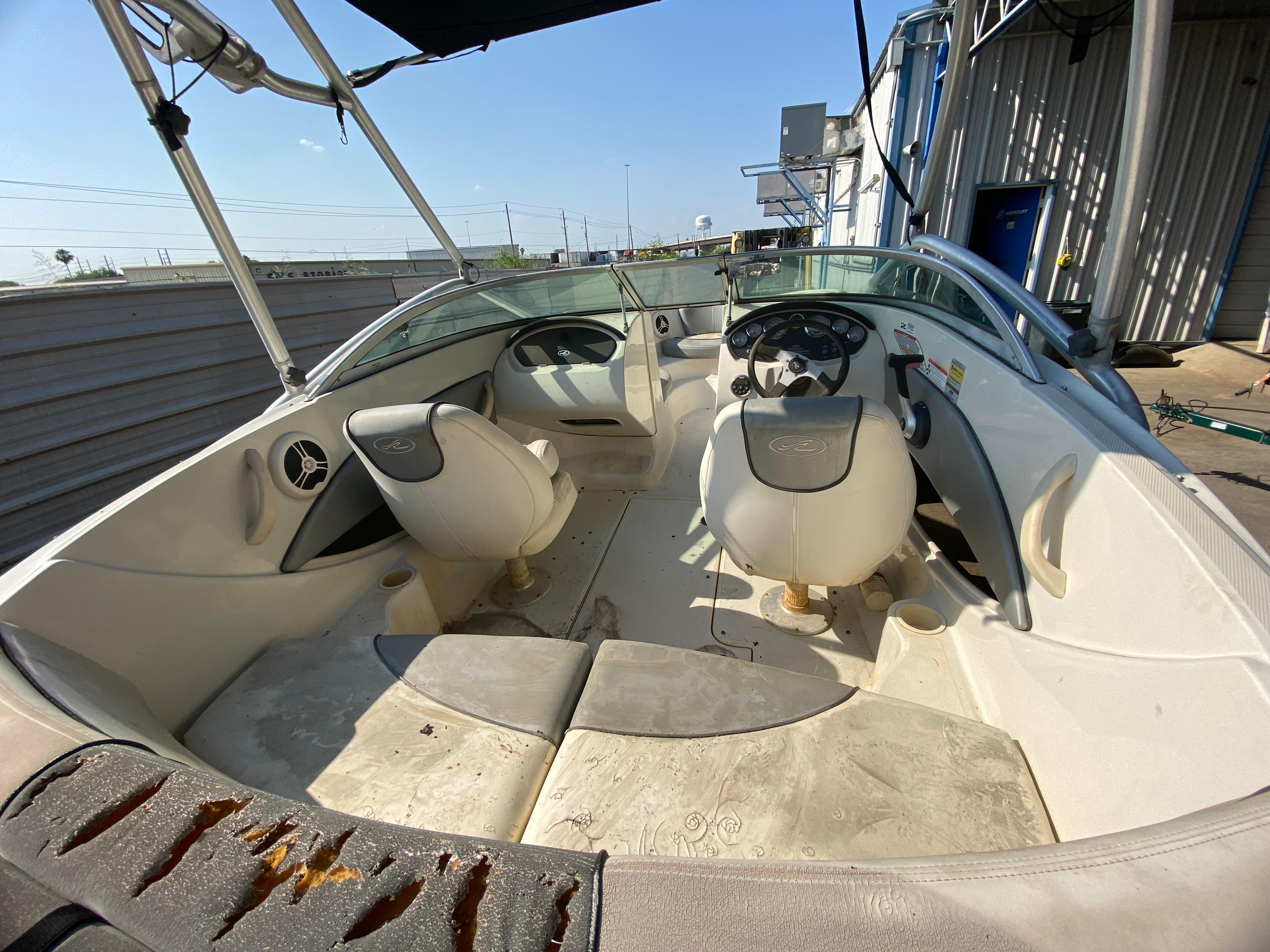 2008 Sea Ray 185 Sport boat interior with seating and steering wheel, docked outdoors.