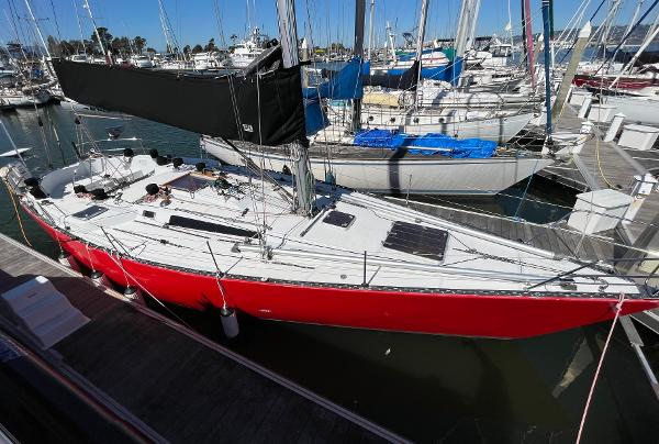 Red 1980 Davidson 44 sailboat docked in marina, surrounded by other boats.