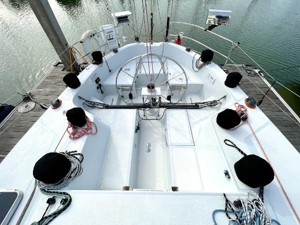 Cockpit of 1980 Davidson 44 sailboat with ropes and winches, docked by calm water.