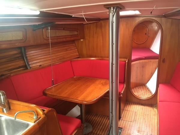 Interior of 1980 Davidson 44 yacht with red seating and wooden finishes.