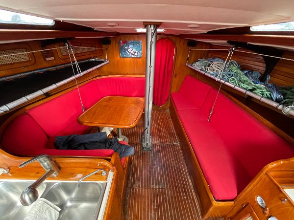 Interior of 1980 Davidson 44 sailboat with red seating and wooden finishes.