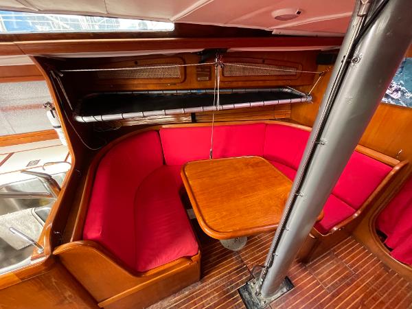1980 Davidson 44 yacht interior with red seating and wooden table.