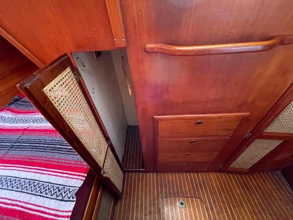 Interior of 1980 Davidson 44 boat with wooden cabinets and striped fabric.