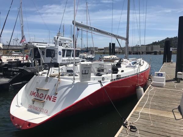 1980 Davidson 44 sailboat docked in a marina, featuring a red hull and white deck.