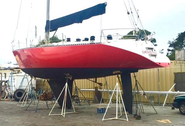 1980 Davidson 44 sailboat with red hull on stands in a boatyard.