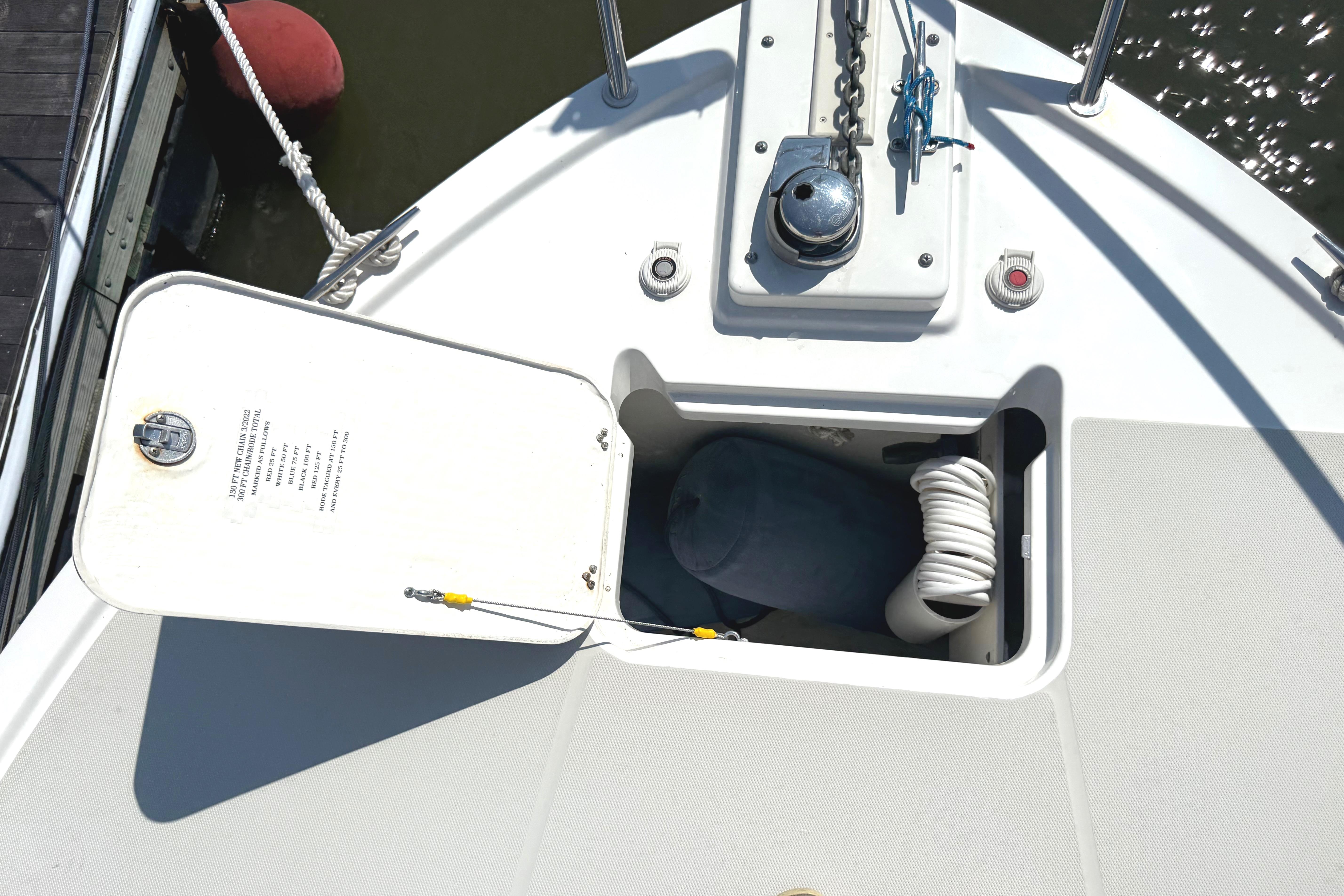 Open hatch on 2013 Back Cove 34 boat deck, showing storage compartment with rope.