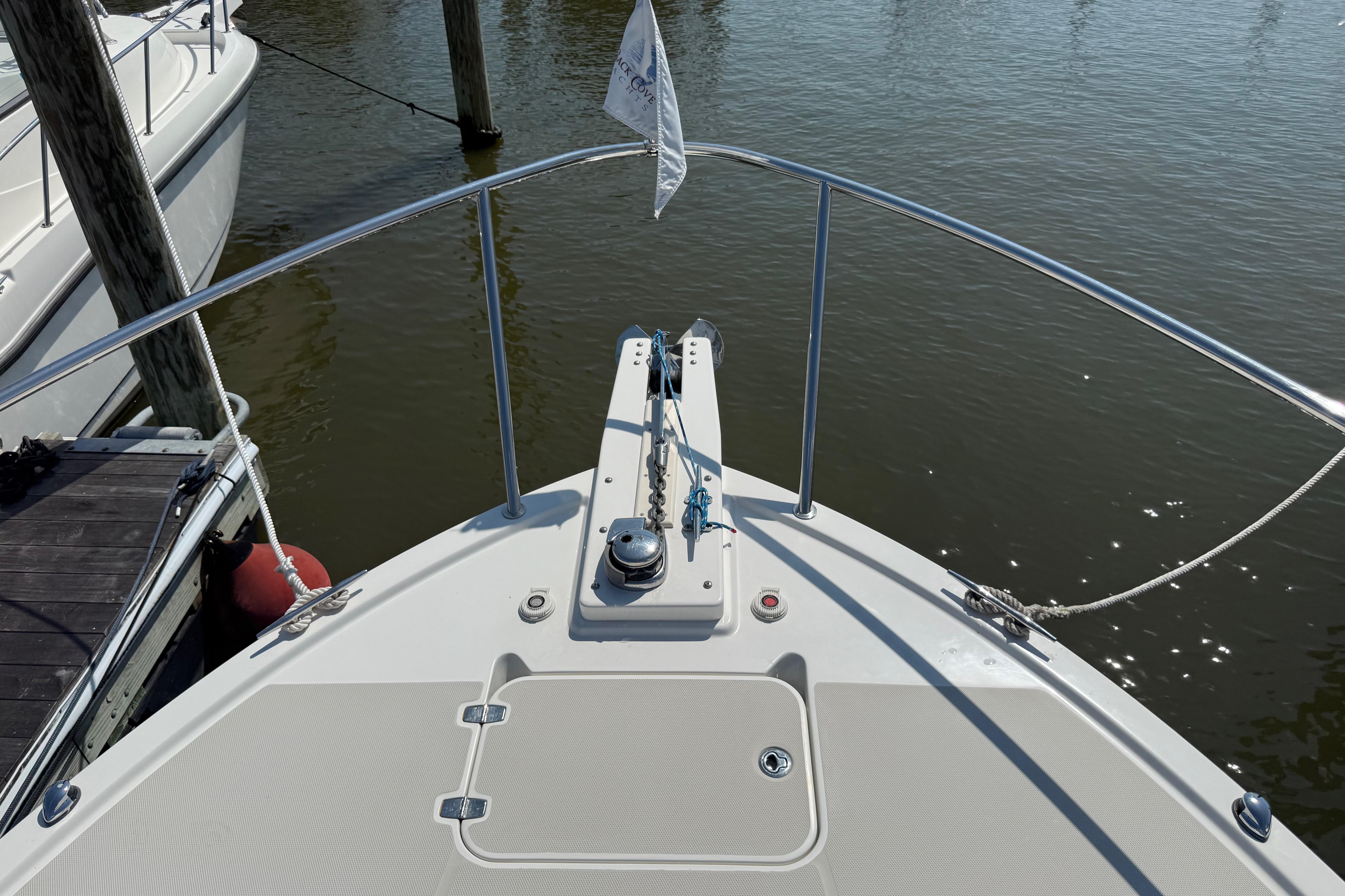 Bow view of 2013 Back Cove 34 boat docked, featuring anchor and railing.