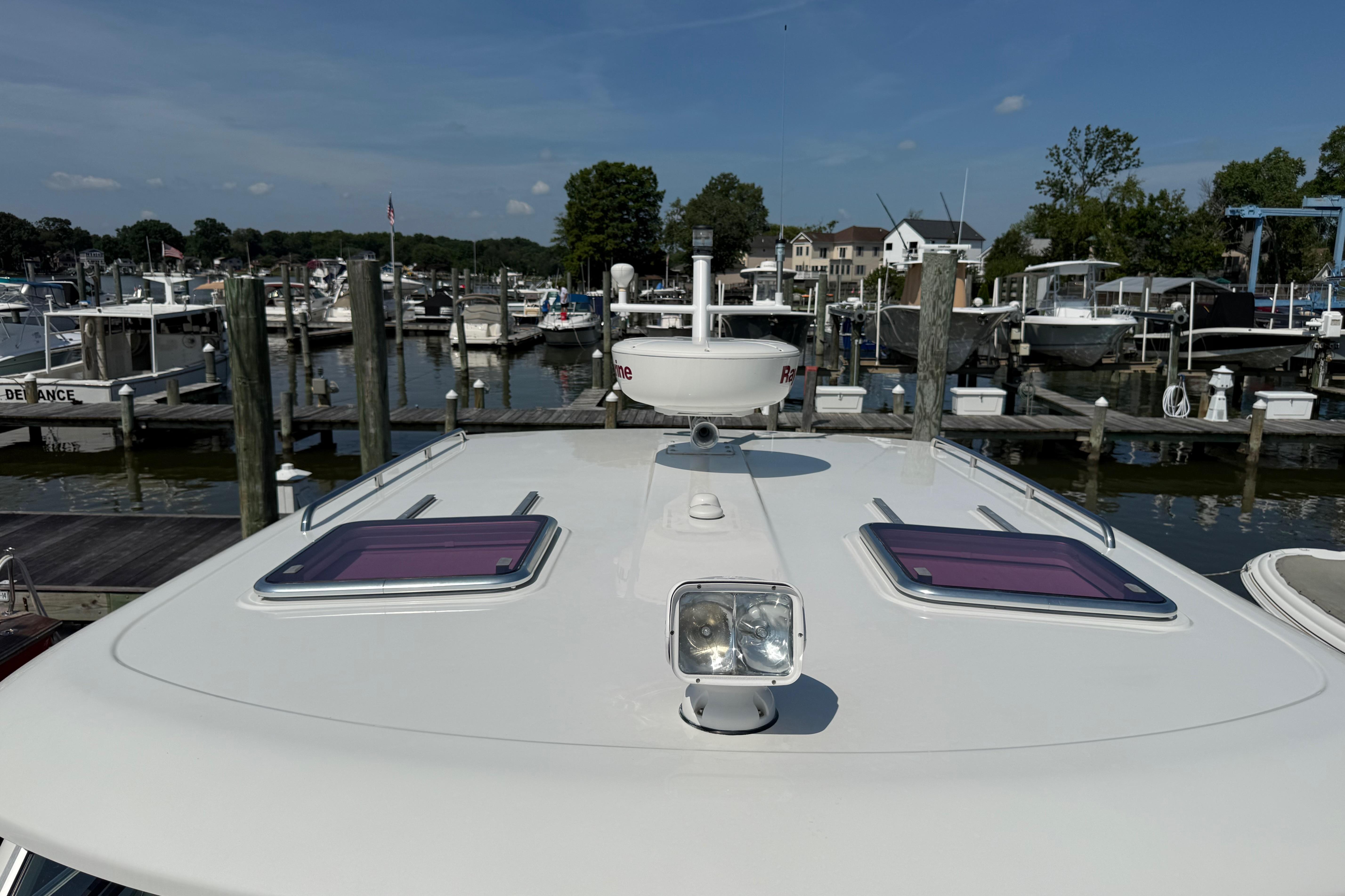2013 Back Cove 34 yacht docked at marina, showcasing roof features and nearby boats.