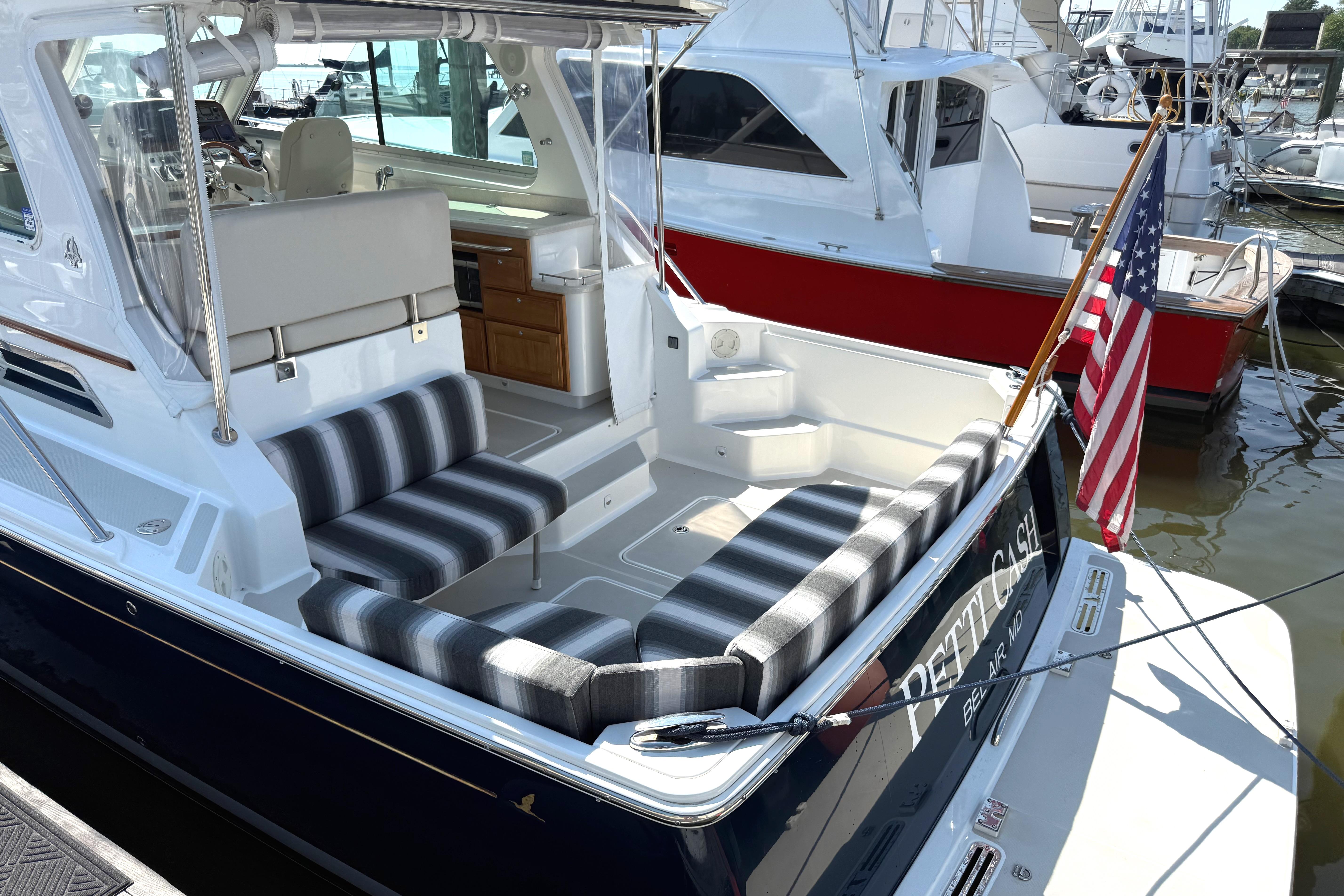 2013 Back Cove 34 boat with striped seating and American flag at marina.