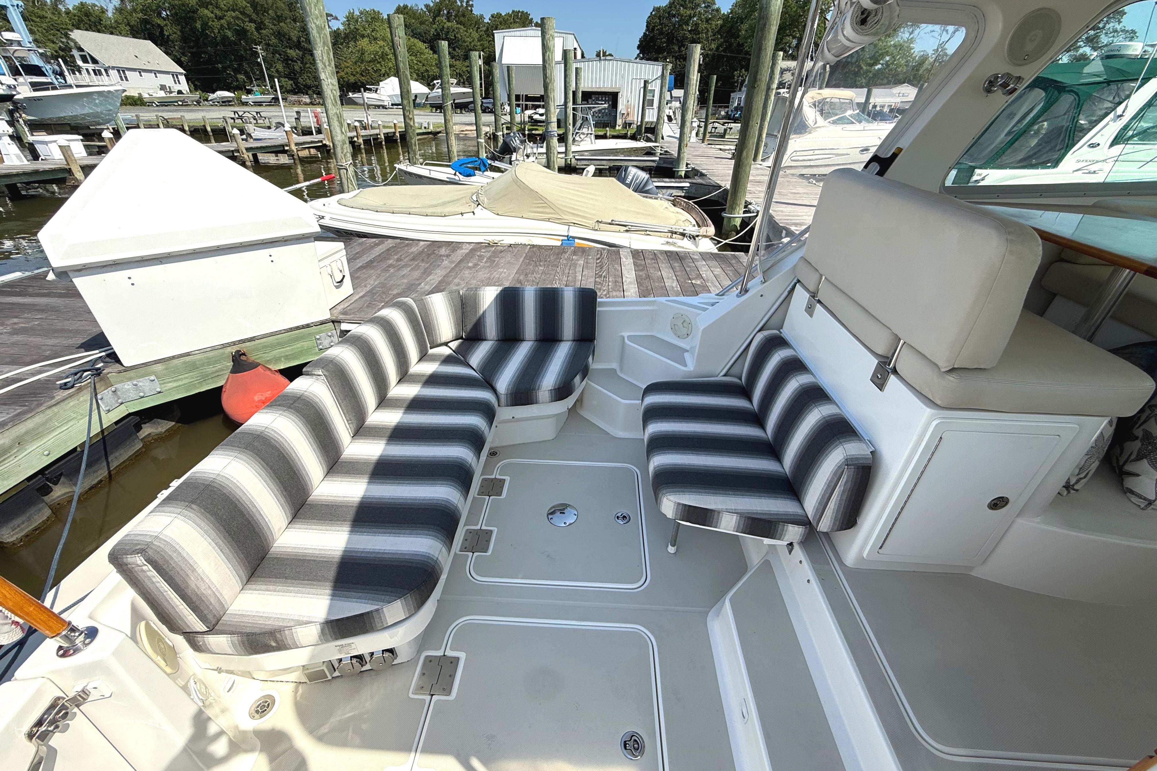 2013 Back Cove 34 boat interior with striped seating at a marina dock.