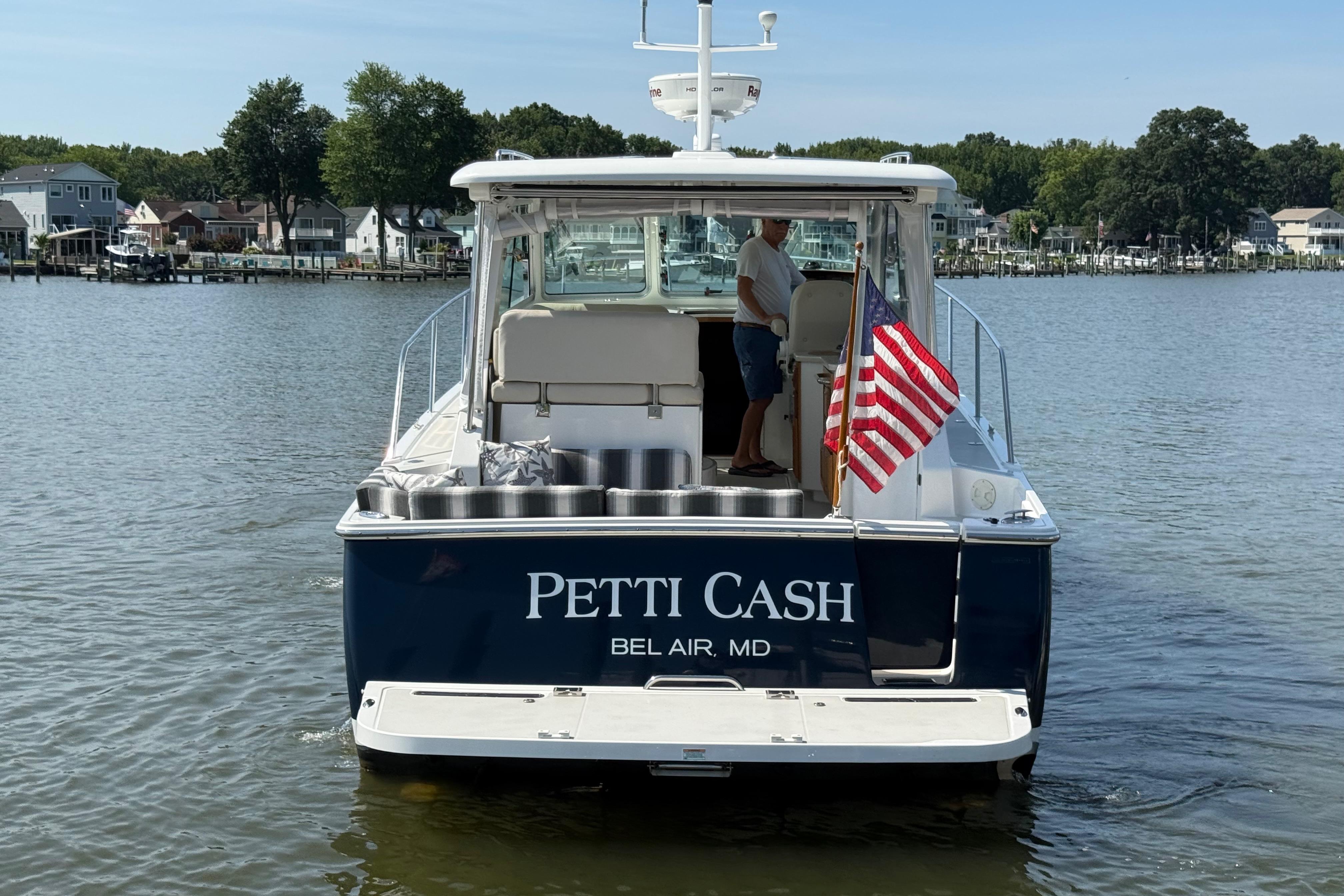 2013 Back Cove 34 boat named u0022Petti Cashu0022 on water, American flag displayed.