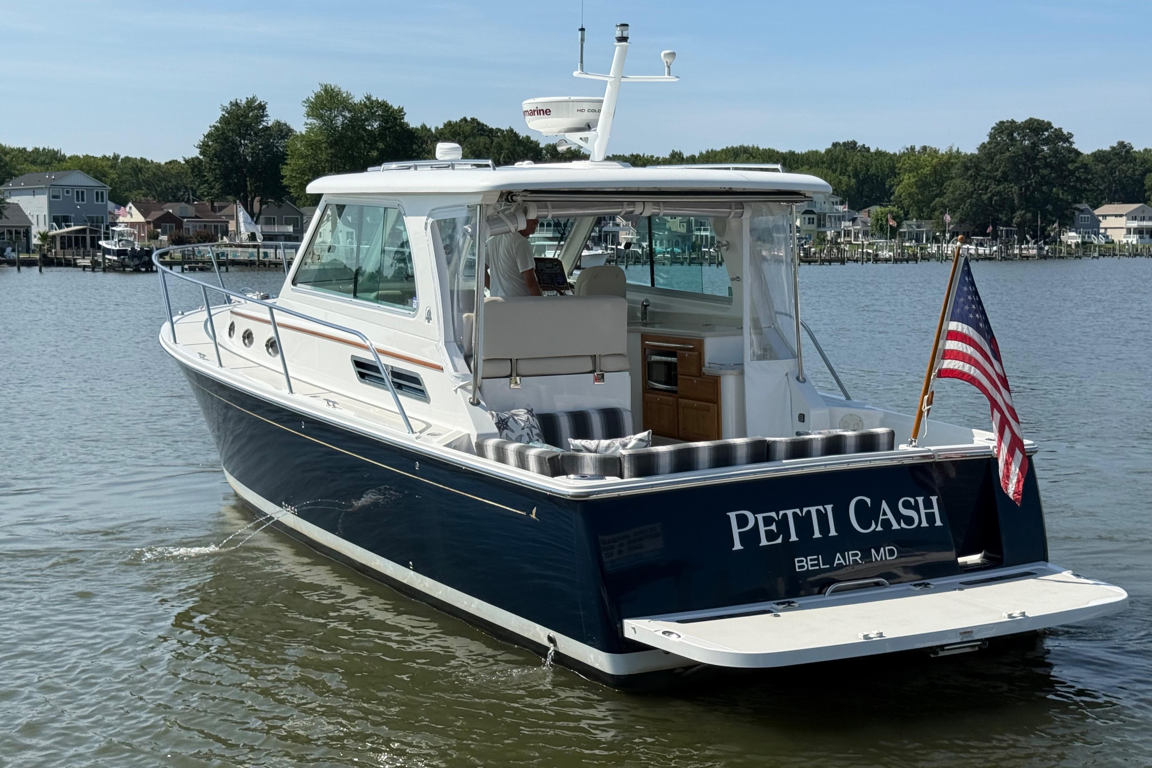 2013 Back Cove 34 boat named u0022Petti Cashu0022 on water, American flag displayed.