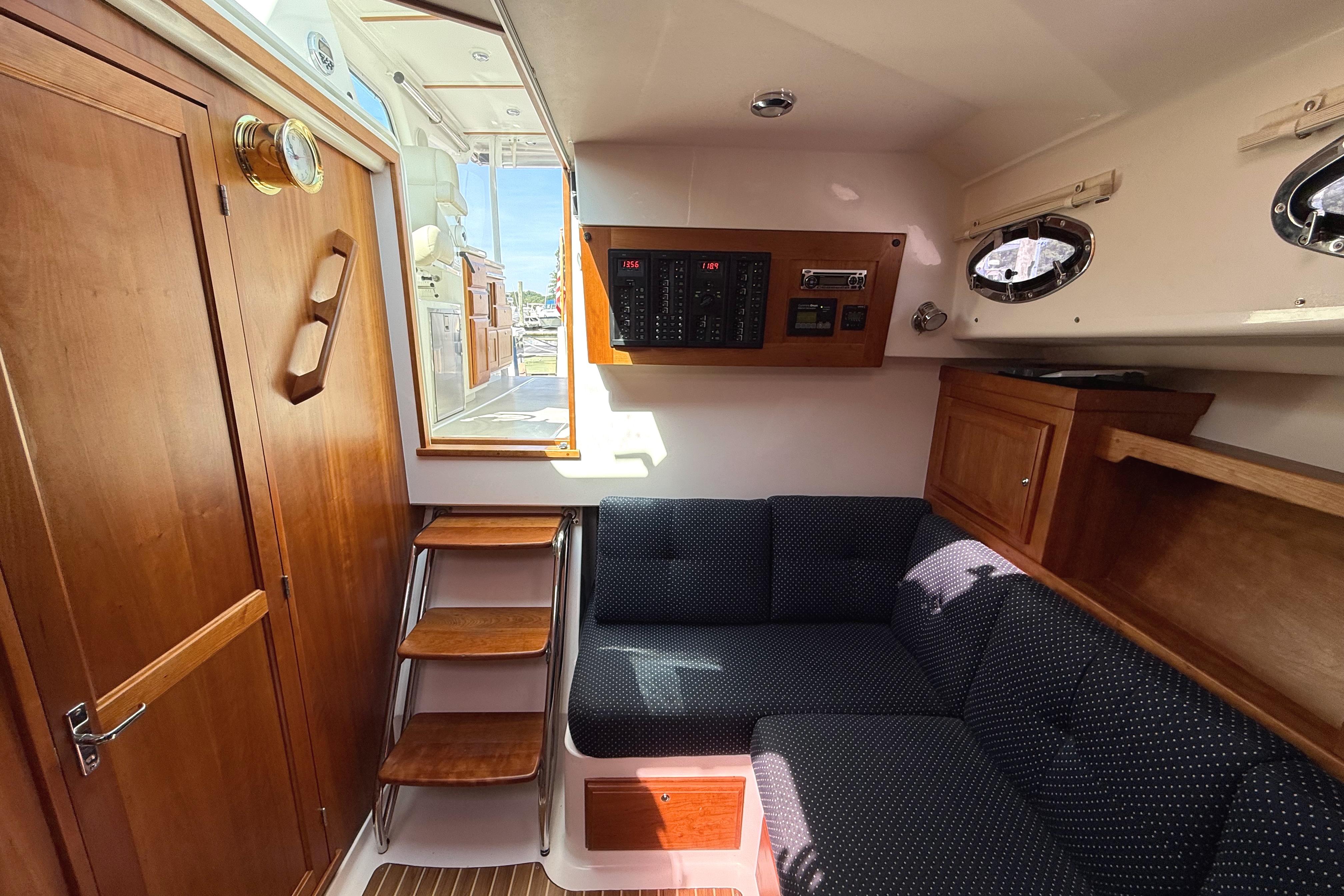 Interior of 2013 Back Cove 34 yacht with wooden cabinetry and navy seating.
