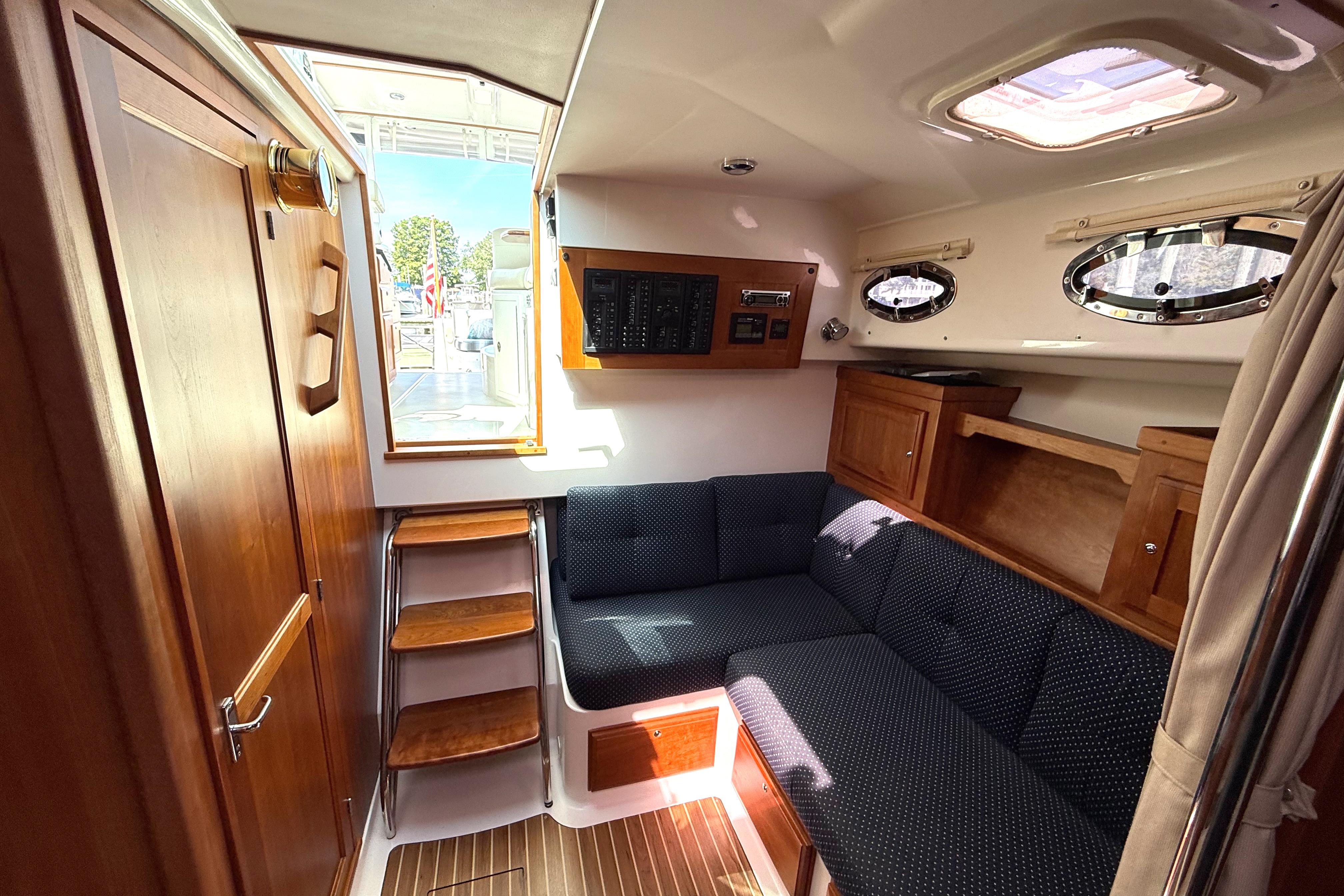 Interior of 2013 Back Cove 34 boat with wooden cabinetry and navy seating.