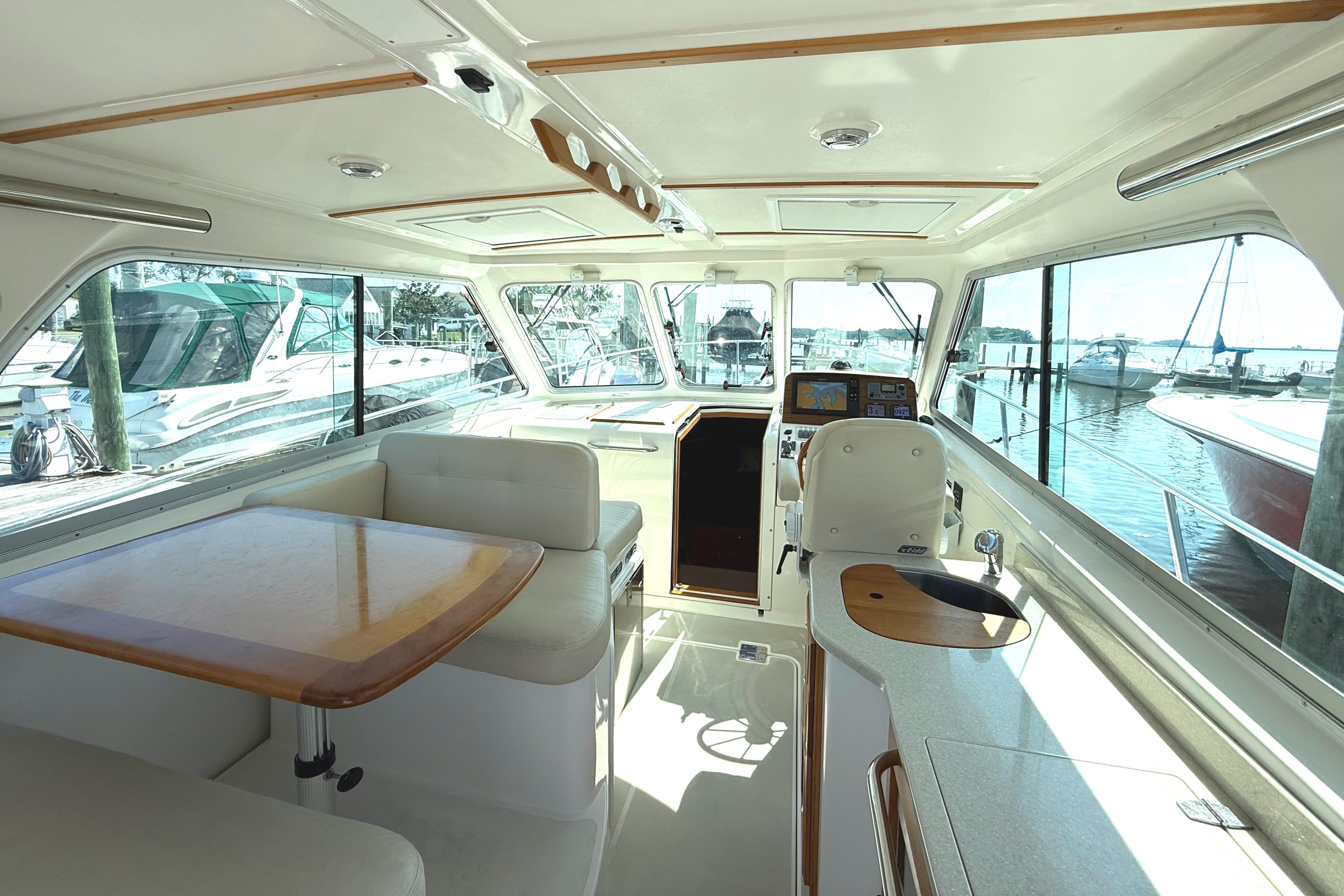 Interior of 2013 Back Cove 34 boat with seating, table, and helm station.