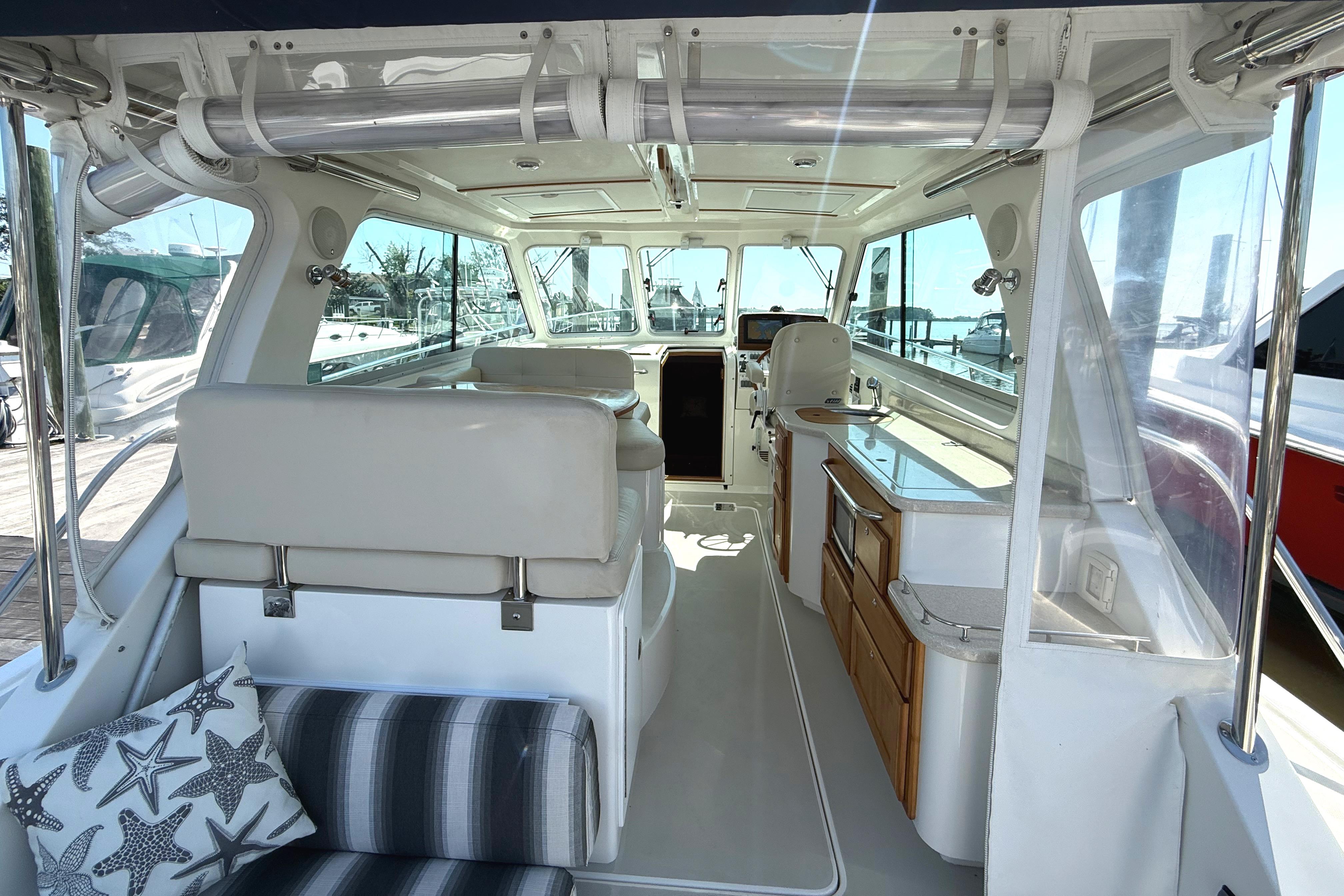 Interior of 2013 Back Cove 34 boat, featuring seating and kitchenette with nautical decor.