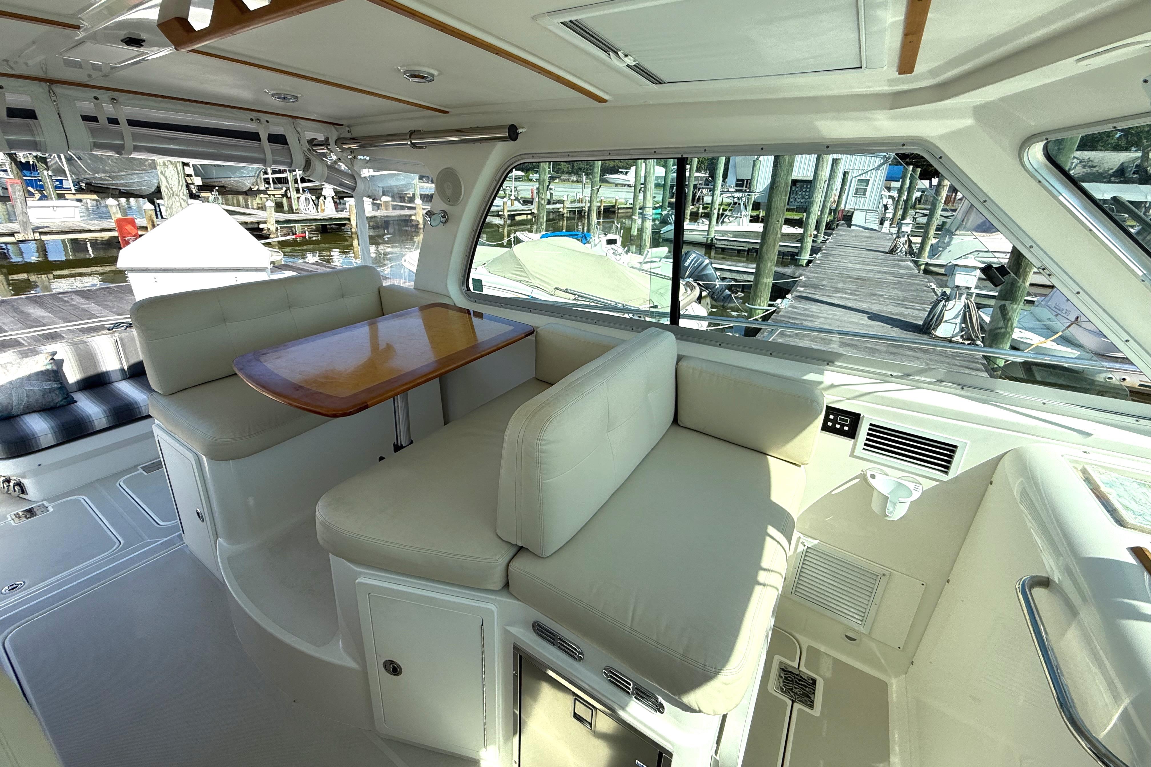 Interior of 2013 Back Cove 34 boat with seating and table, dockside view.