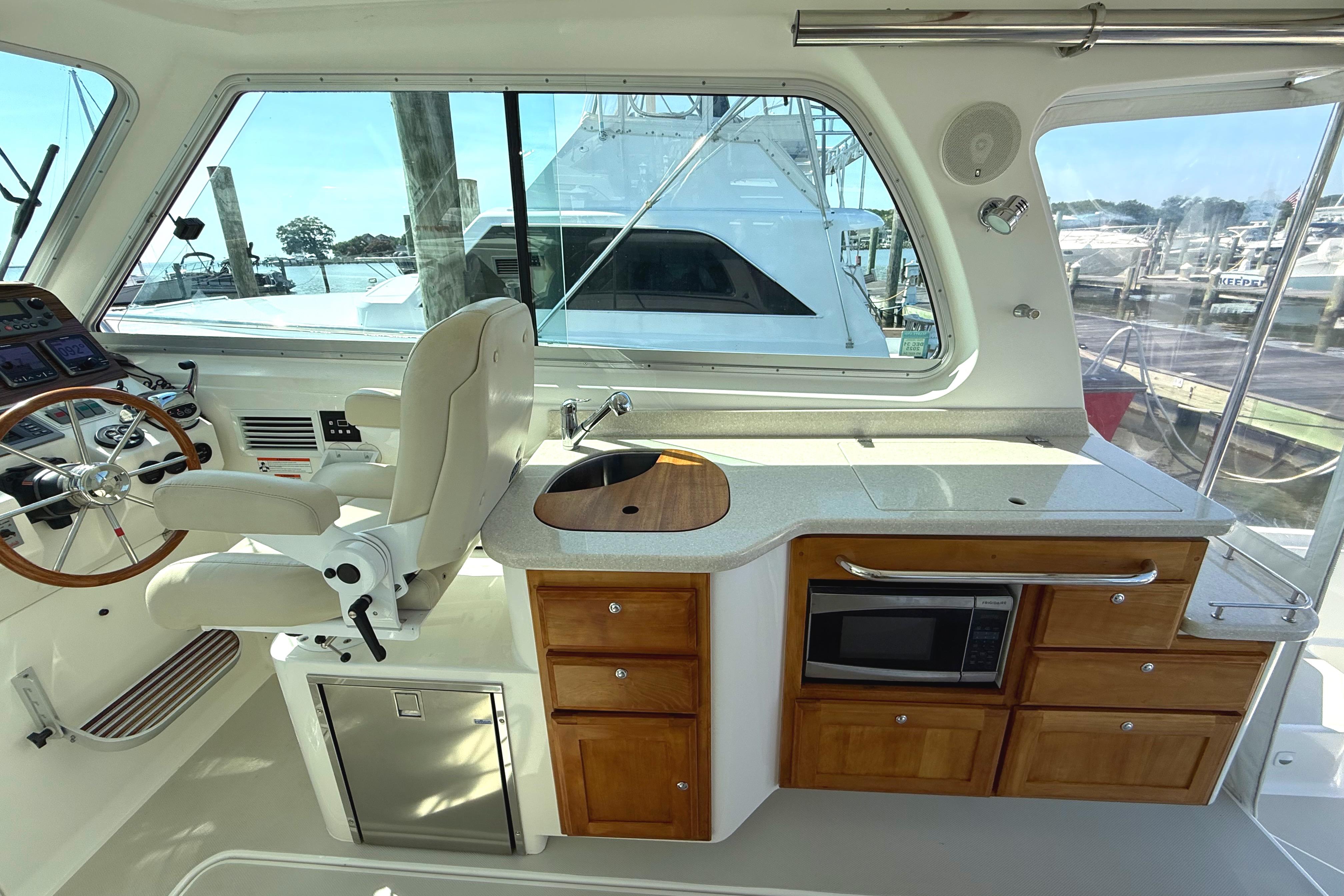 Interior of 2013 Back Cove 34 yacht with helm, kitchenette, and microwave.