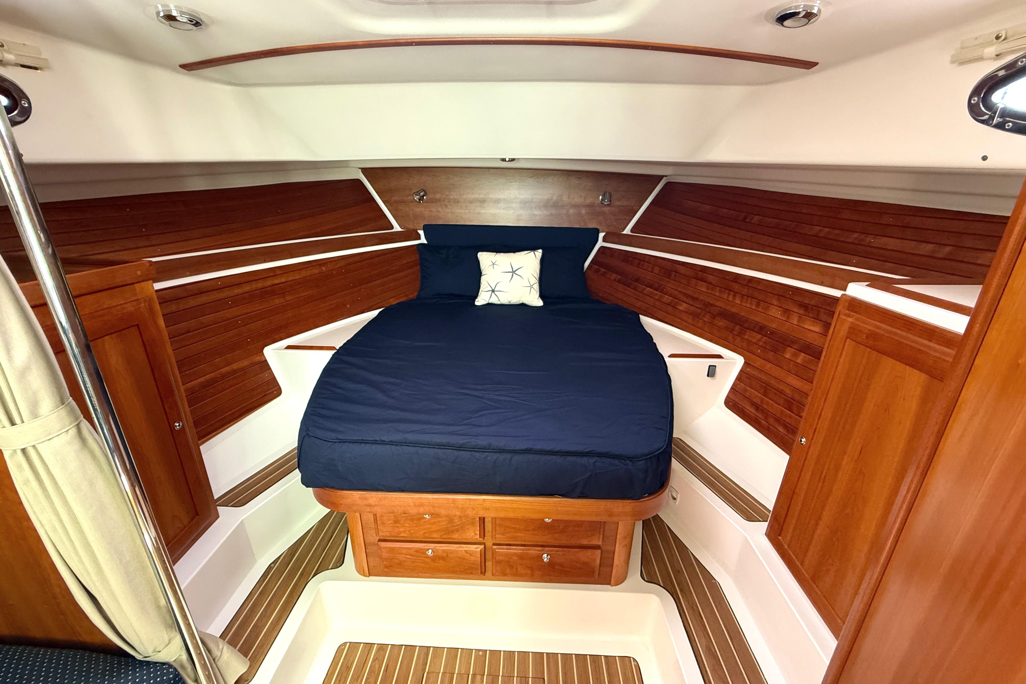 2013 Back Cove 34 cabin interior with wooden finish and cozy bed.