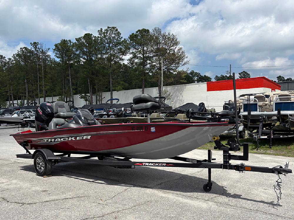 2024 Tracker Pro Team 190 TX boat on trailer, parked outdoors under cloudy sky.