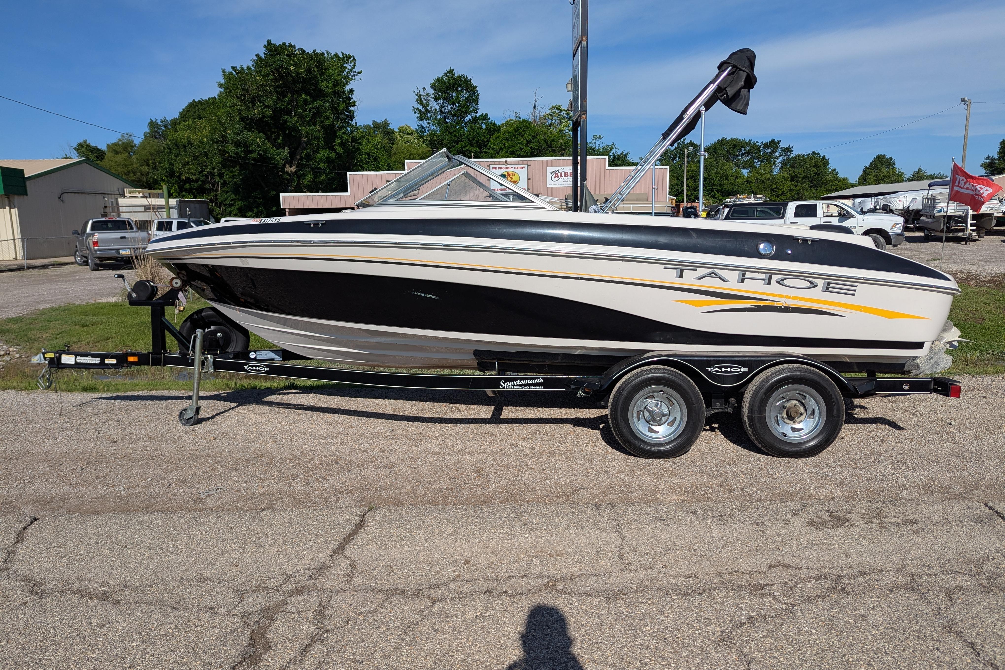 2006 Tahoe Q6 Sport boat on trailer, parked outdoors on a sunny day.