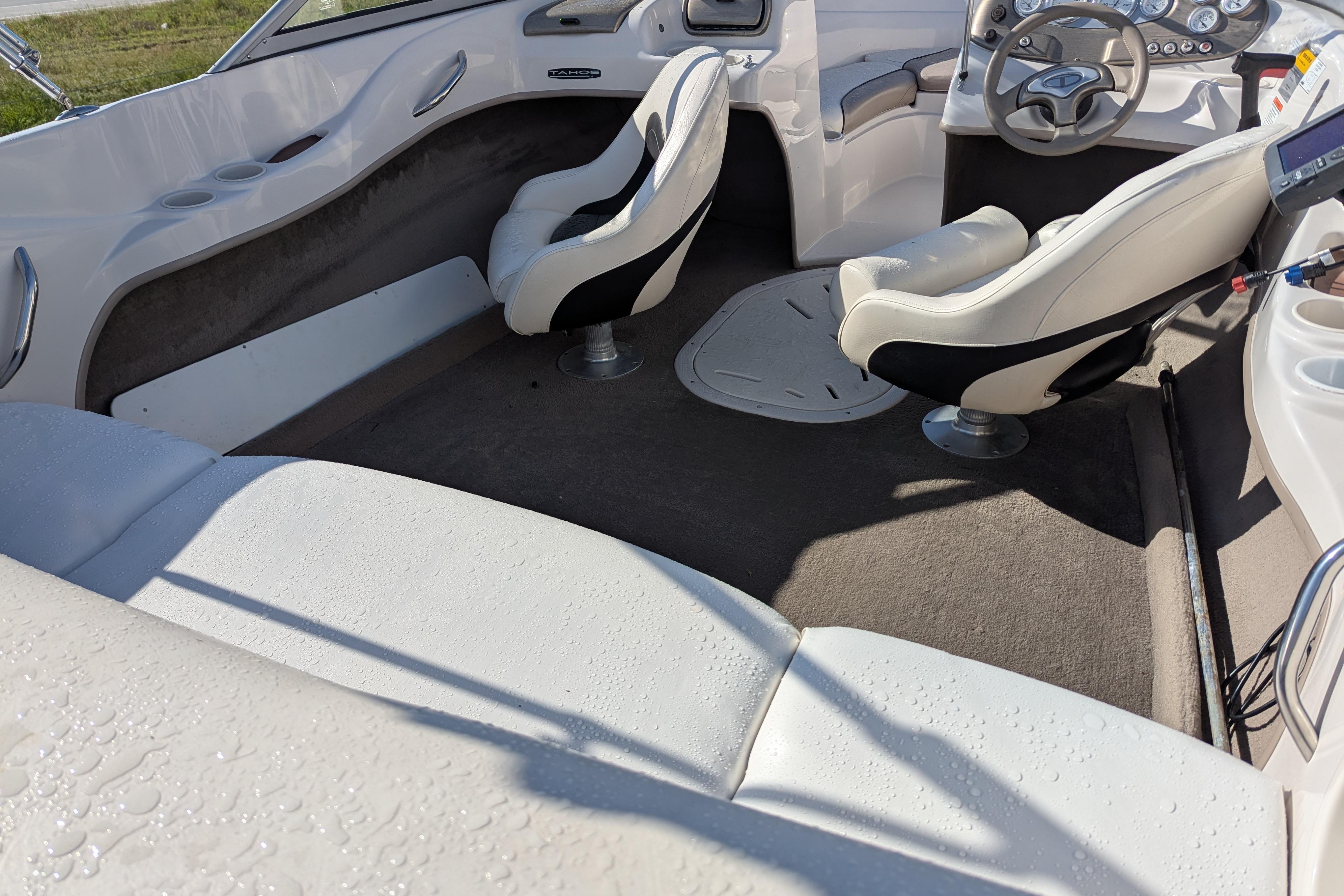 Interior of a 2006 Tahoe Q6 Sport boat with white seating and steering wheel.