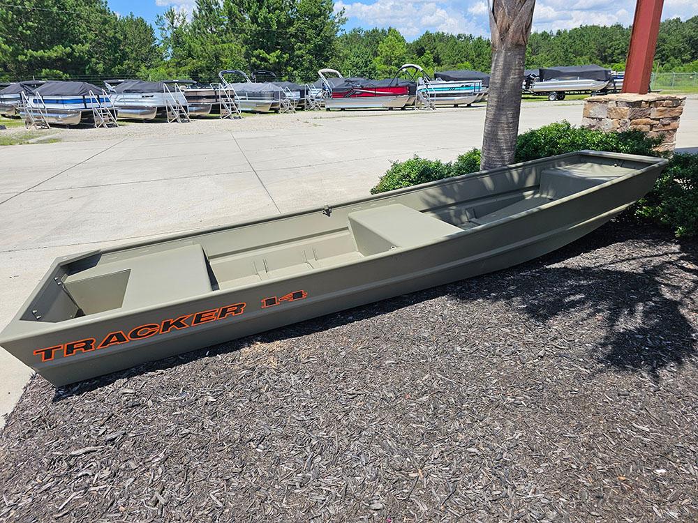 2025 Tracker Grizzly 14 Jon boat displayed outdoors, surrounded by greenery and other boats.