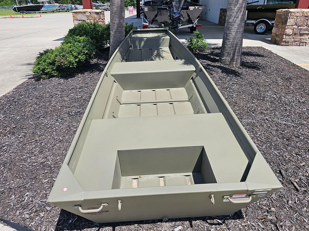 2025 Tracker Grizzly 14 Jon boat displayed outdoors on mulch, near greenery.