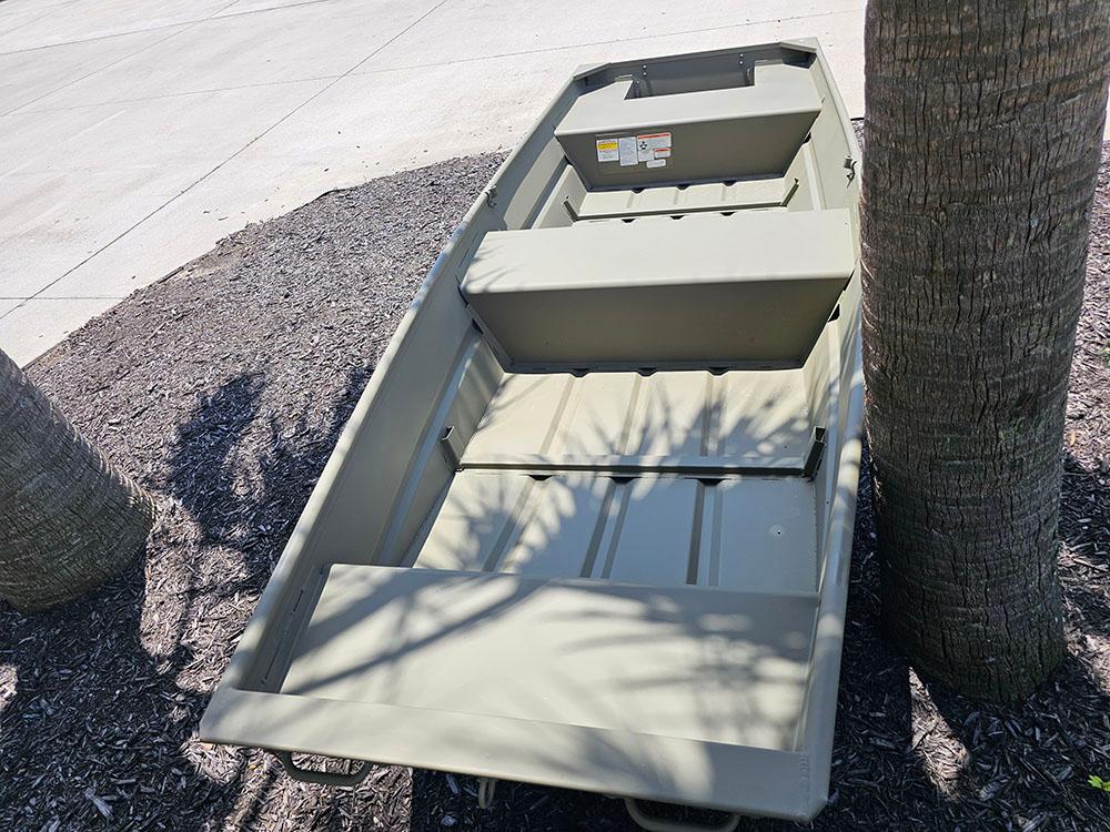 2025 Tracker Grizzly 14 Jon boat on display near palm trees.