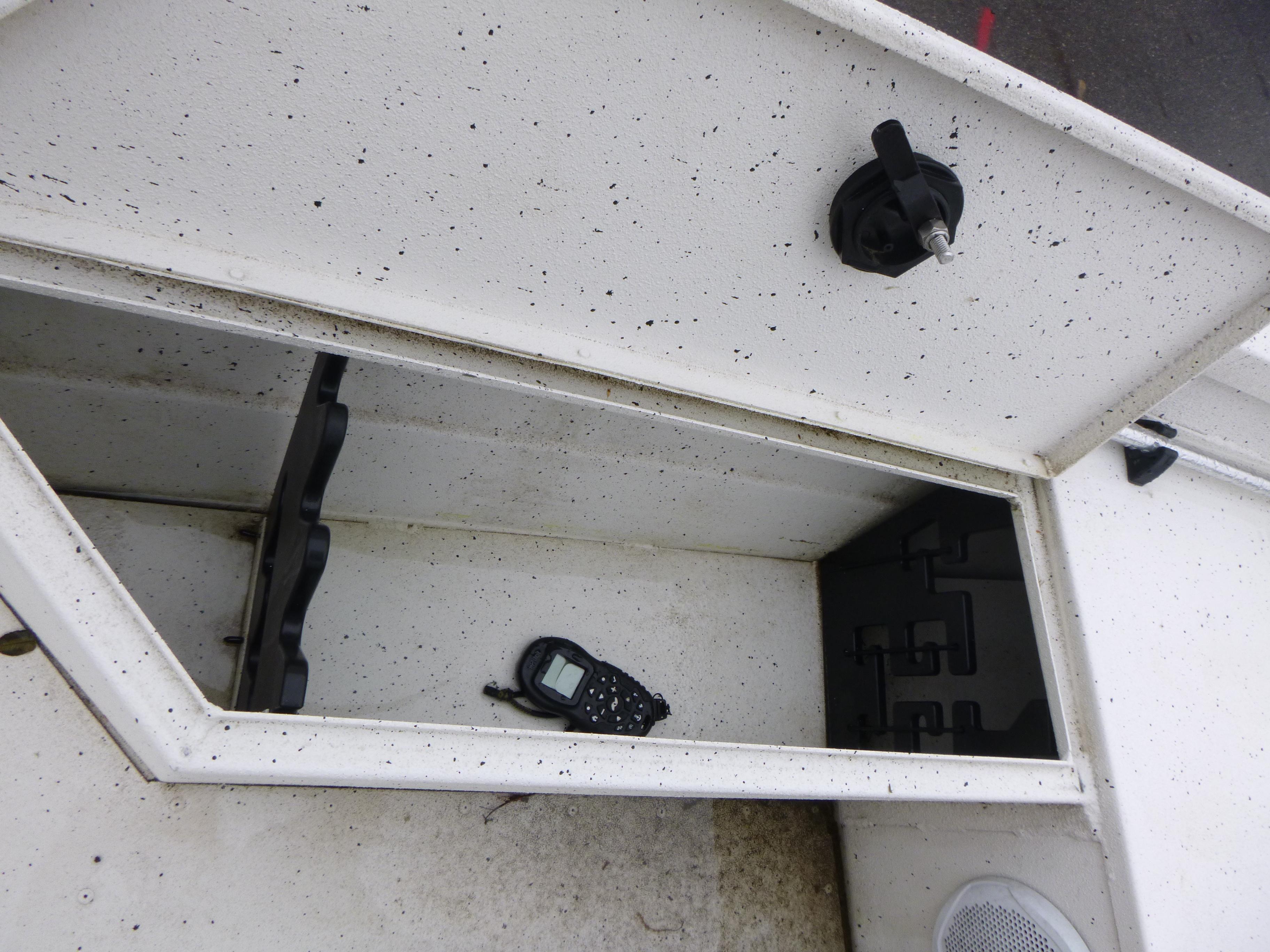 2017 G3 Bay 18 DLX boat storage compartment with a handheld device inside.