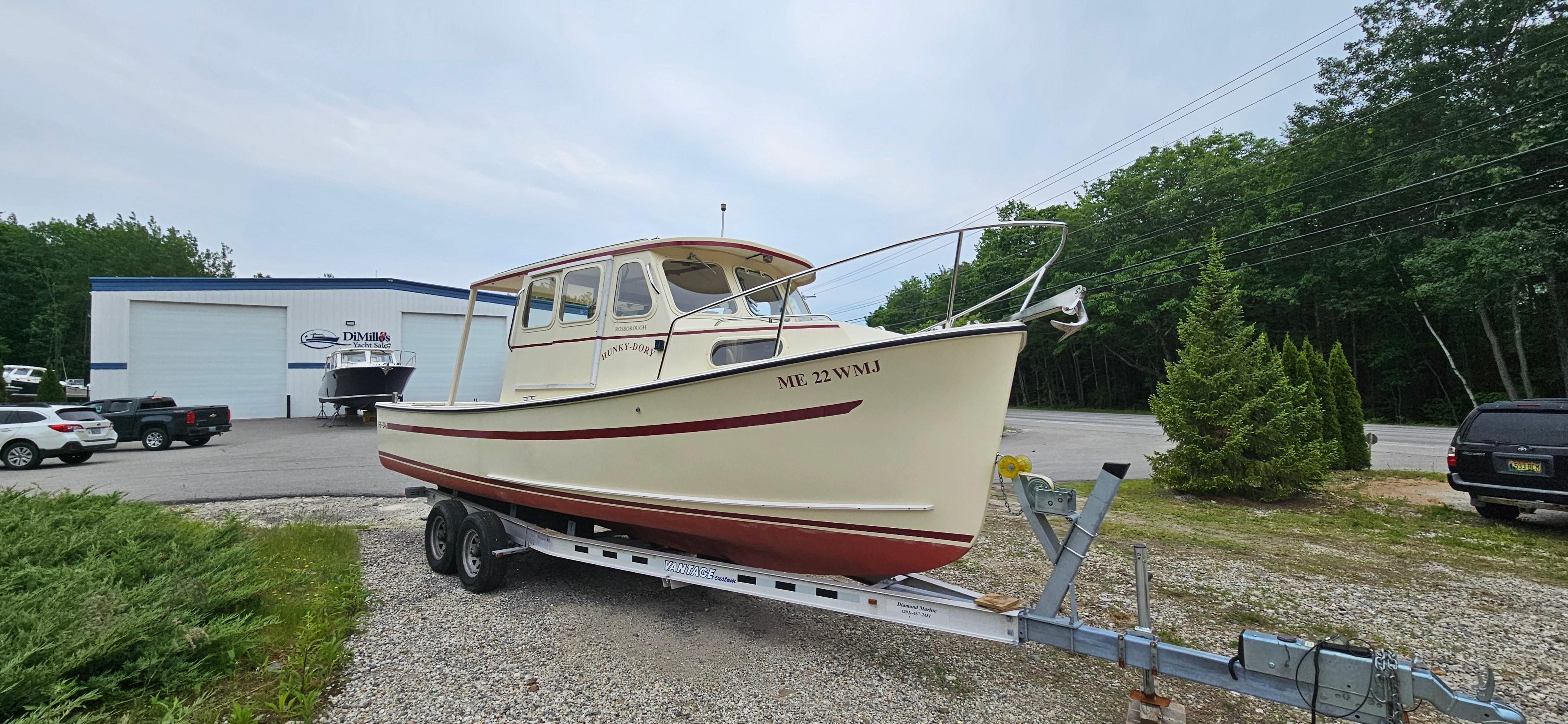 2001 Rosborough RF-246 Custom Wheelhouse boat on trailer, parked near a building.