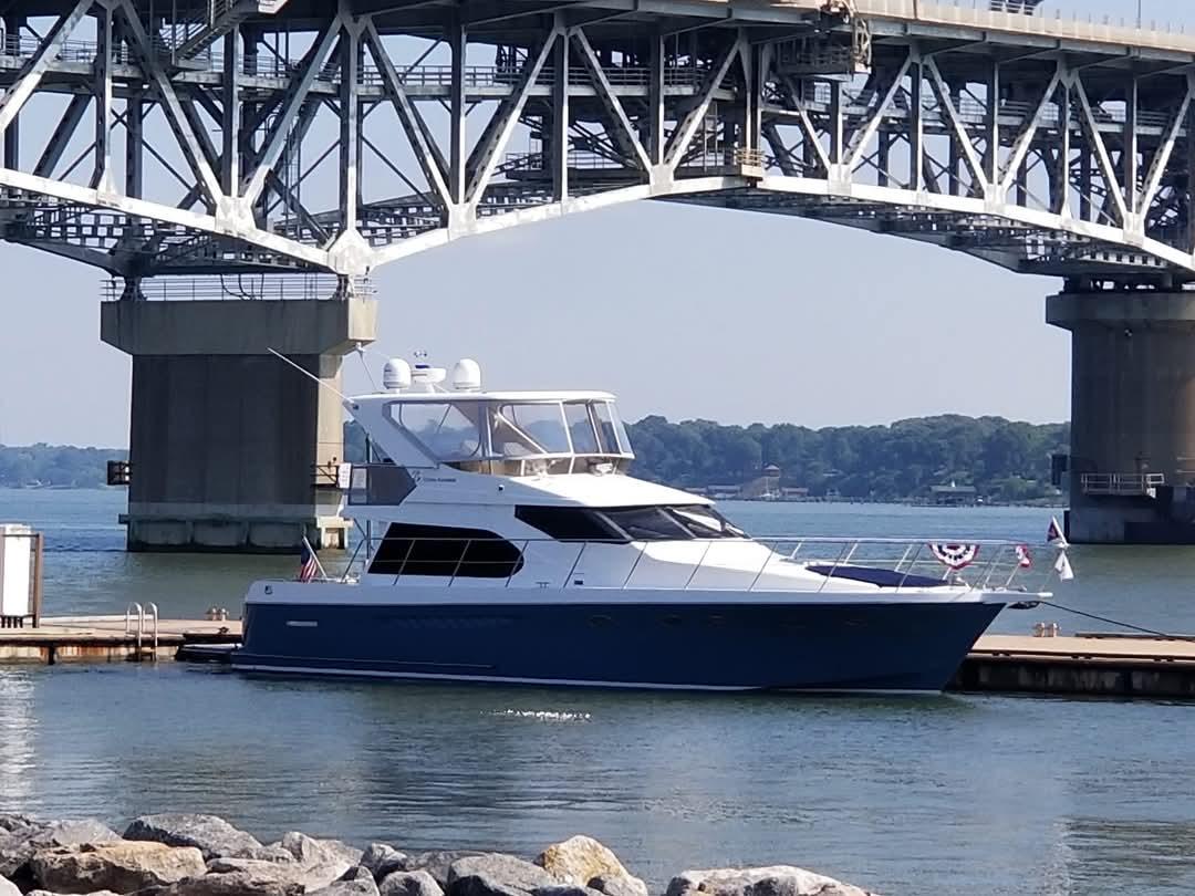 Ocean Alexander 52 Sedan yacht, 2005 model, docked under a large bridge.