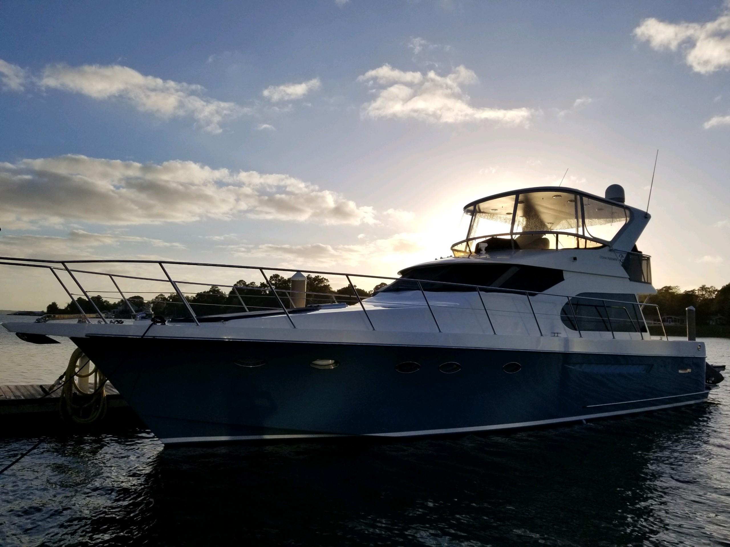 2005 Ocean Alexander 52 Sedan yacht docked at sunset, silhouetted against a vibrant sky.