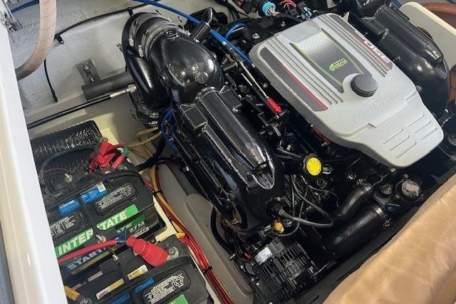 Engine compartment of a 2011 Chris-Craft Launch 22 boat, featuring batteries and engine components.
