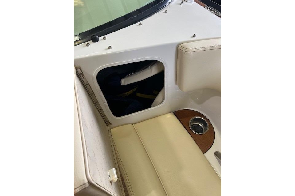 2011 Chris-Craft Launch 22 interior with beige seating and storage compartment.