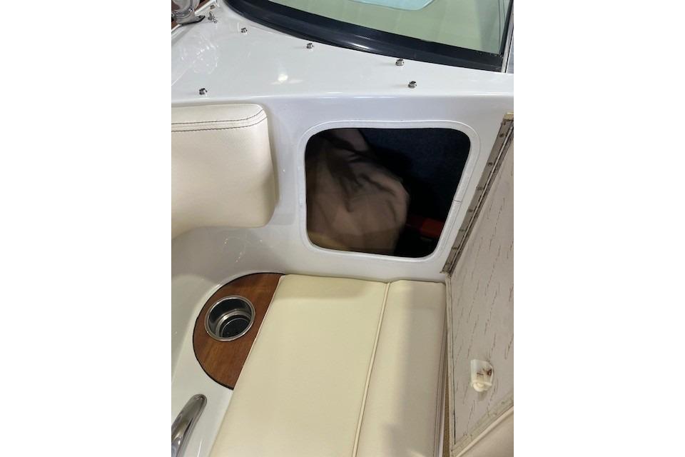 2011 Chris-Craft Launch 22 interior storage compartment with beige seating and cup holder.