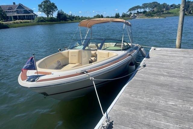 2011 Chris-Craft Launch 22 boat docked on a sunny lake with scenic background.