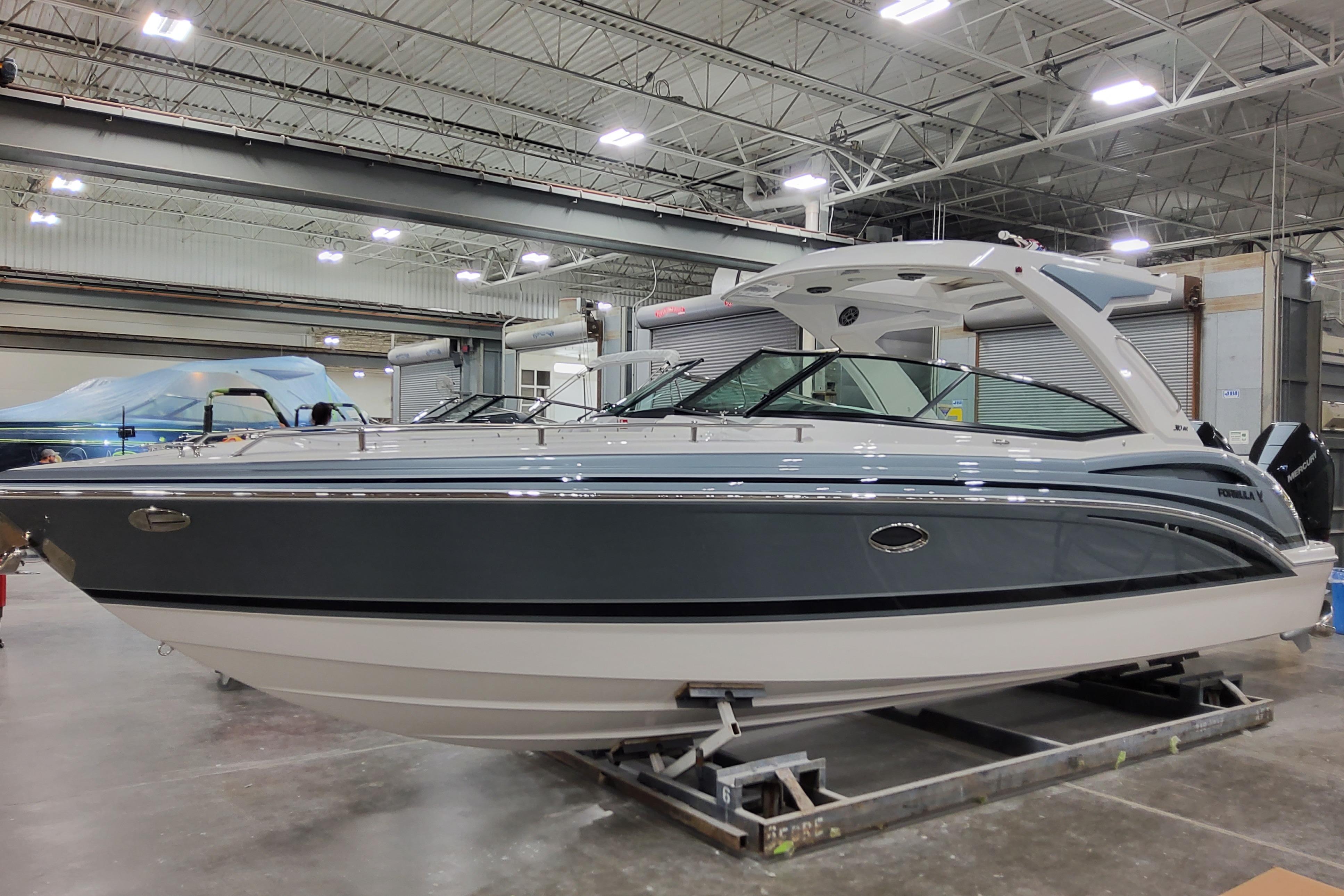 2026 Formula 310 Bowrider OB boat in a showroom, side view.